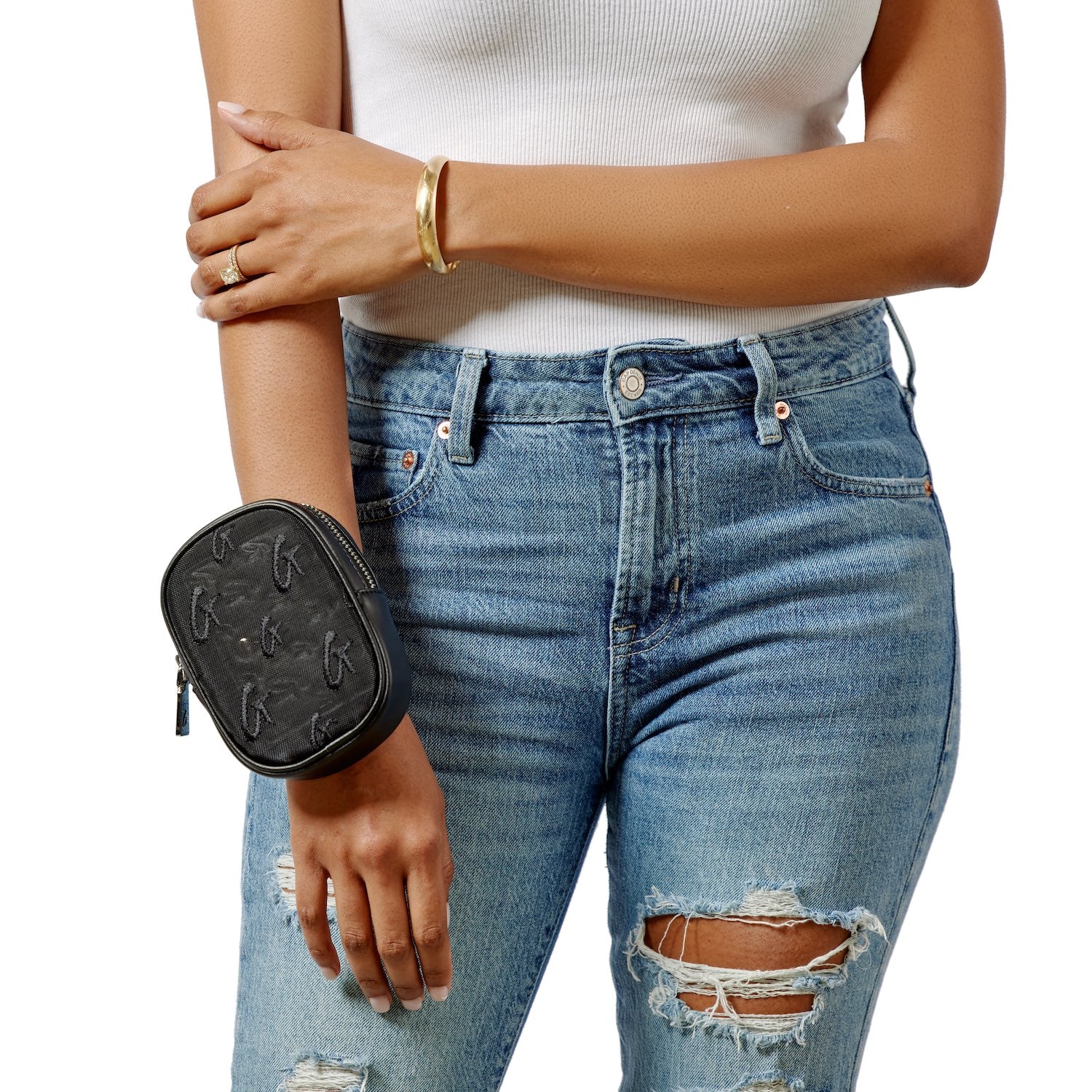 Black mesh monogram wristlet with embroidered logo, worn on a woman's wrist, paired with casual jeans and a white top.