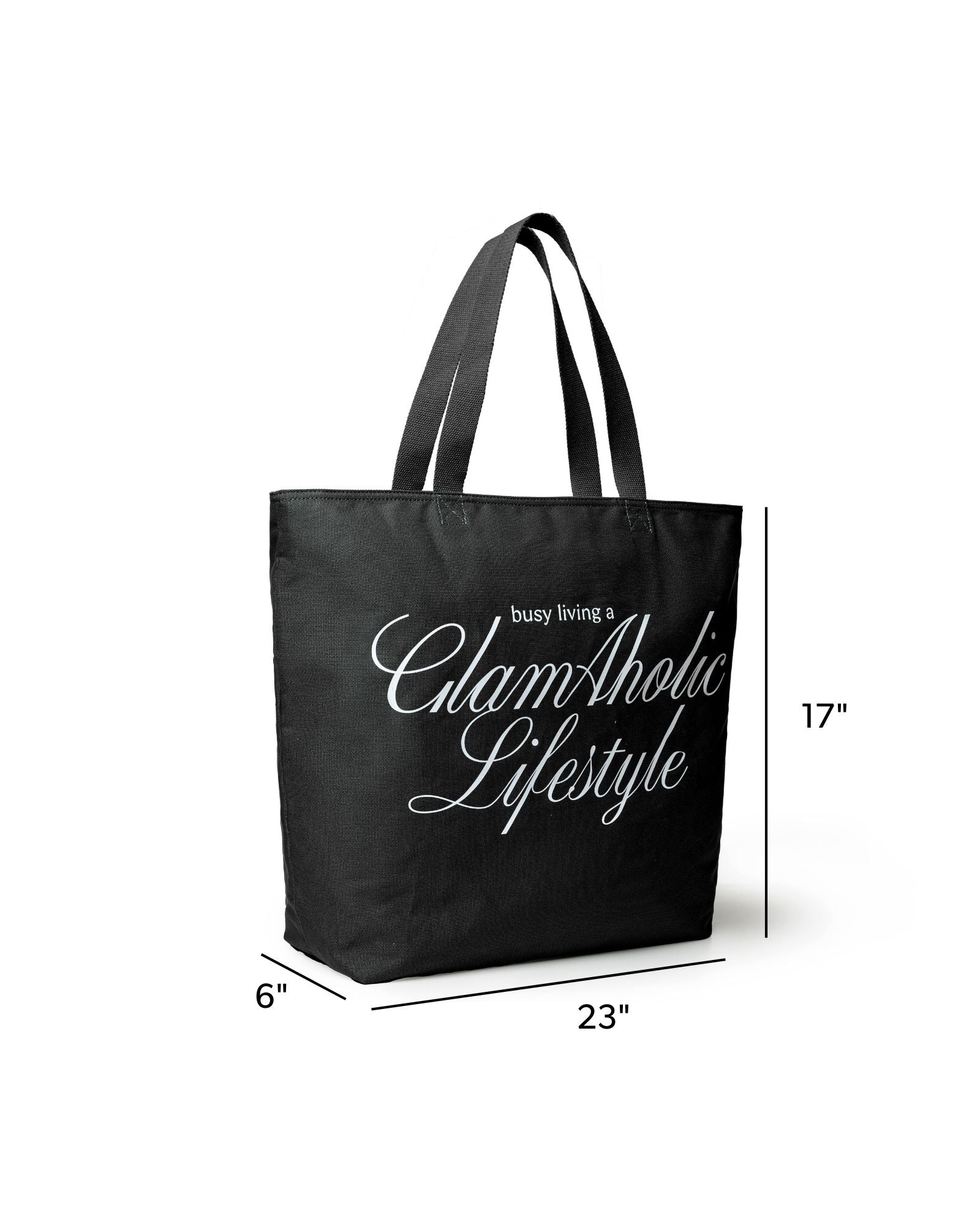 Black canvas tote bag featuring "Busy Living a GlamAholic Lifestyle" text, measuring 23 inches wide and 17 inches tall.