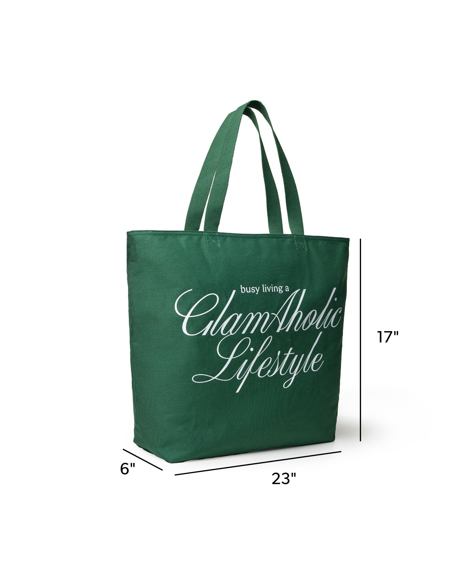 Green canvas tote bag with "busy living a GlamAholic Lifestyle" printed in white, measuring 23 inches wide and 17 inches tall.
