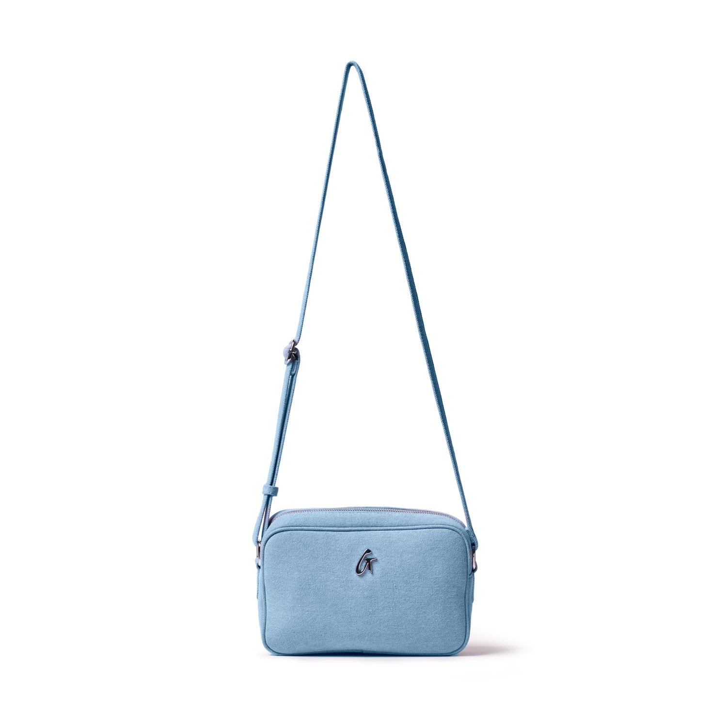 Light blue denim camera bag with a silver logo, adjustable strap, and zippered closure, designed for carrying camera gear.