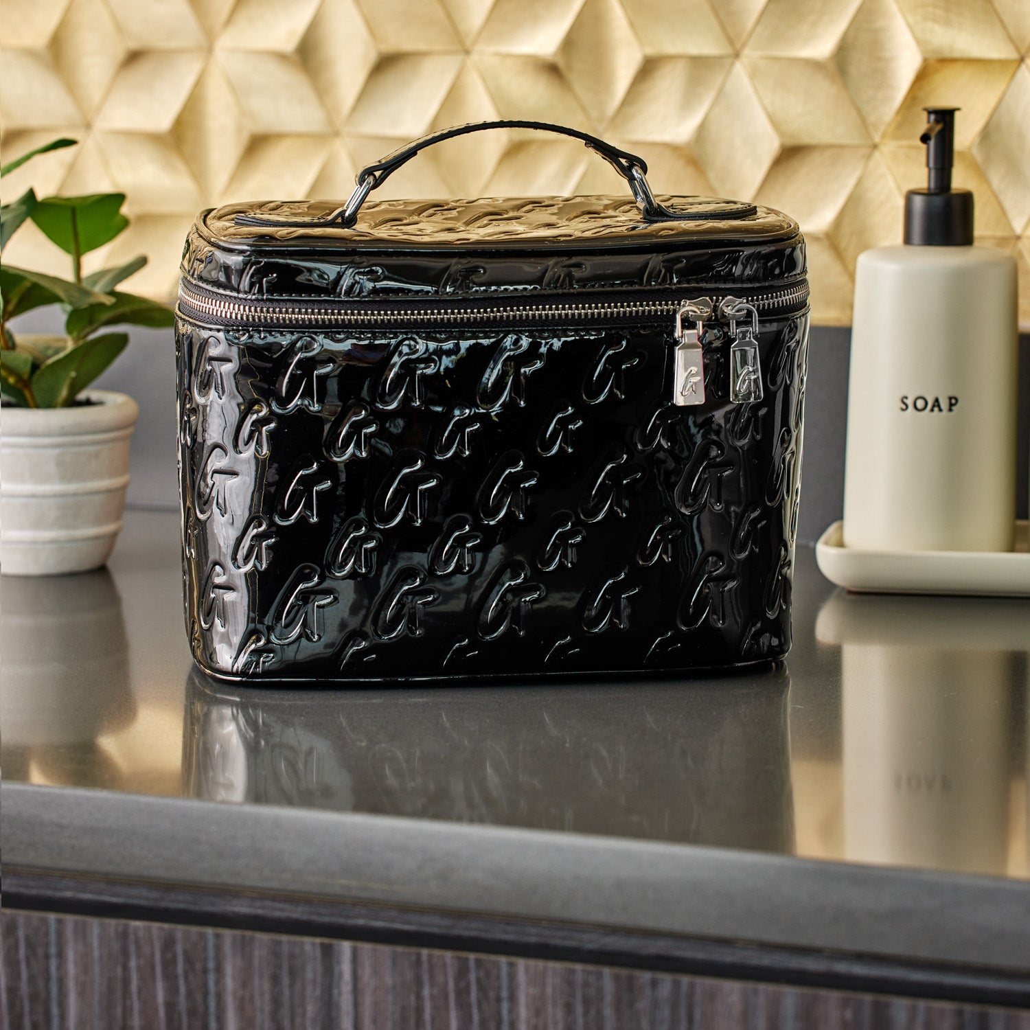 Large black monogram toiletry bag with a glossy finish, embossed with repeating "G" pattern, and a top handle.
