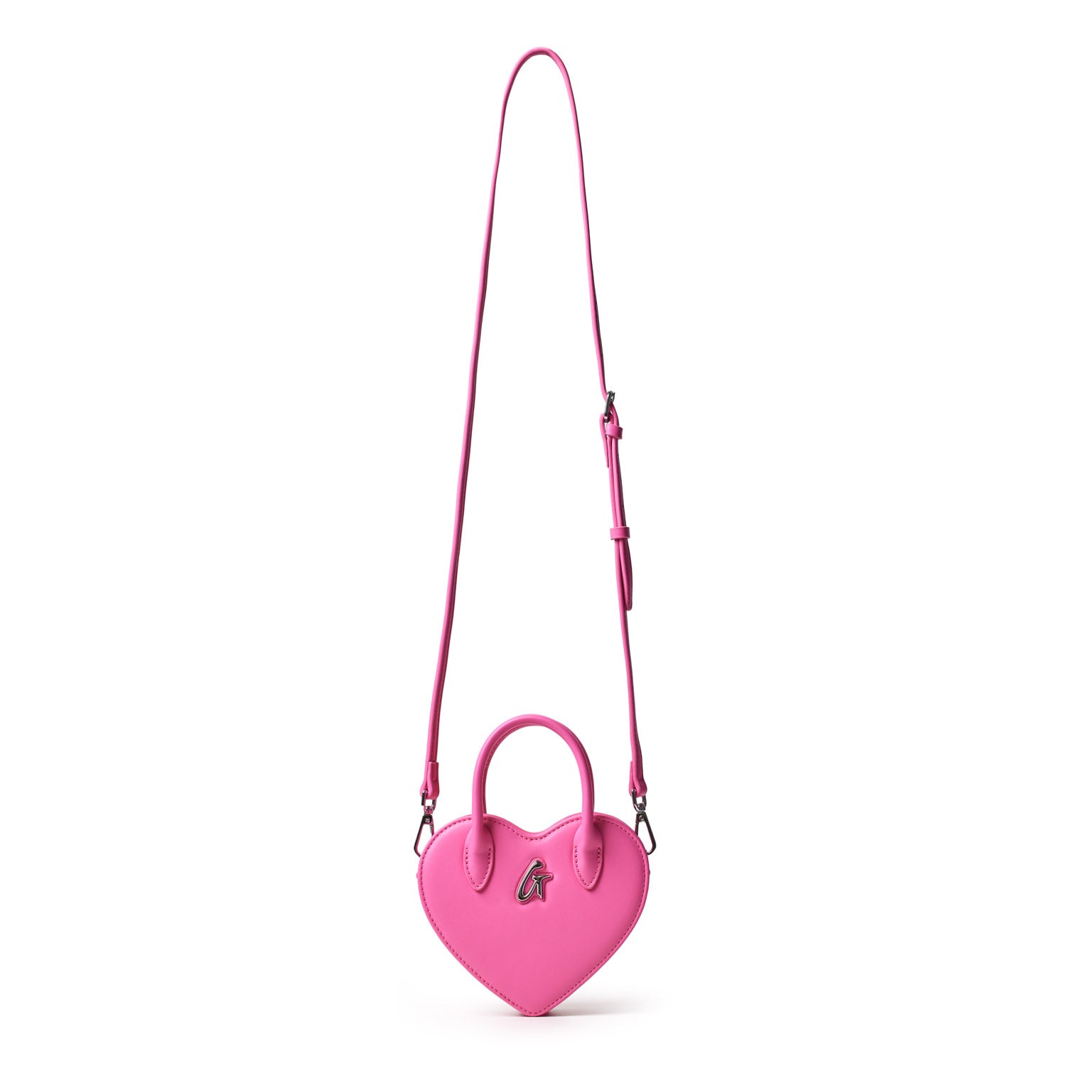 Small pink heart-shaped bag with top handles, a shoulder strap, and a metallic logo on the front.