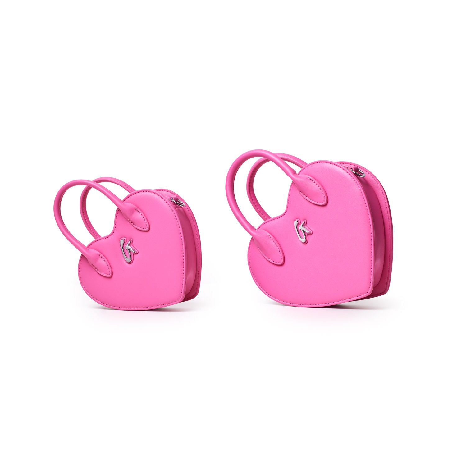 Two pink mini heart-shaped bags with handles and silver logo accents, perfect for small essentials and stylish outings.
