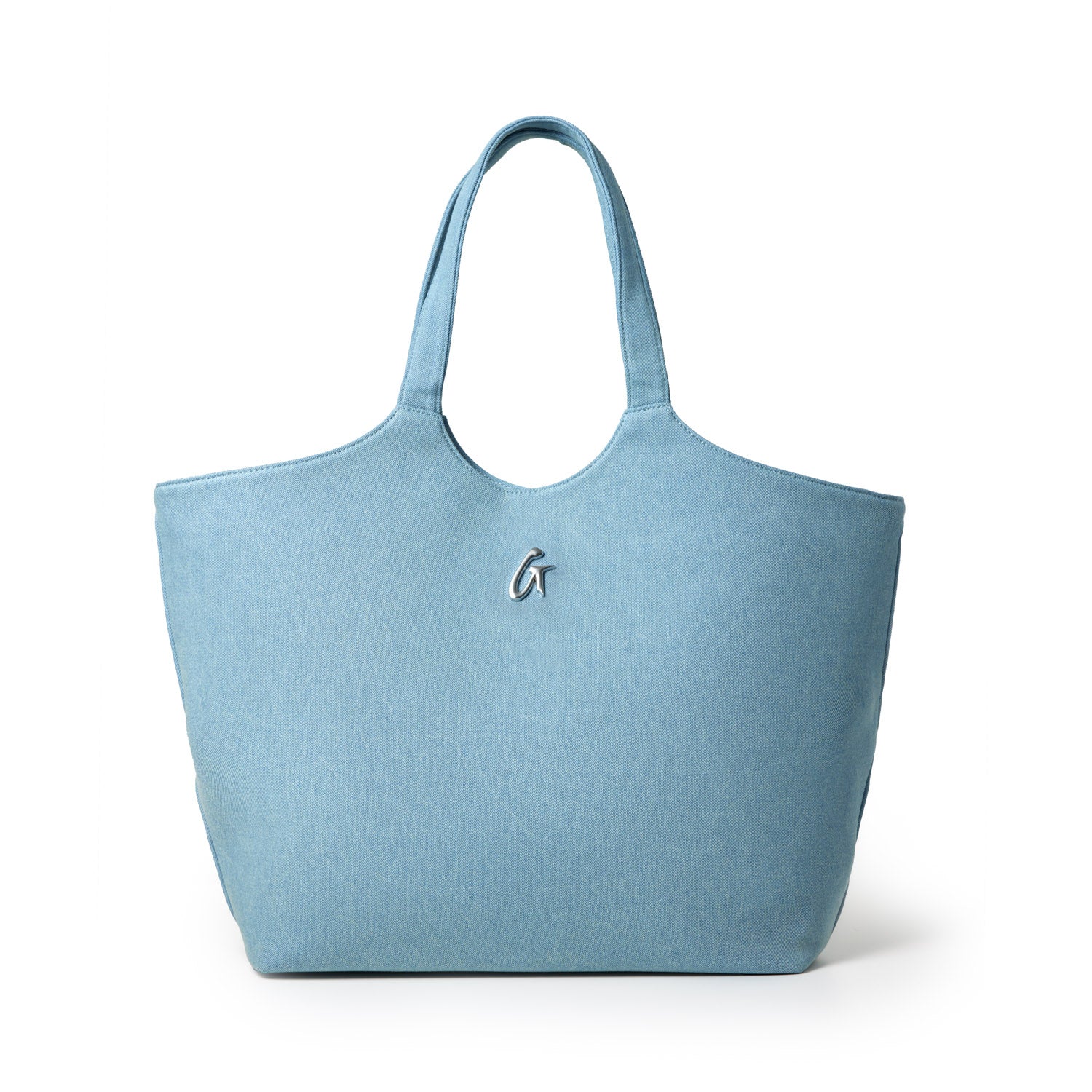 Light blue denim maxi tote bag with shoulder straps and a metallic logo embellishment on the front.