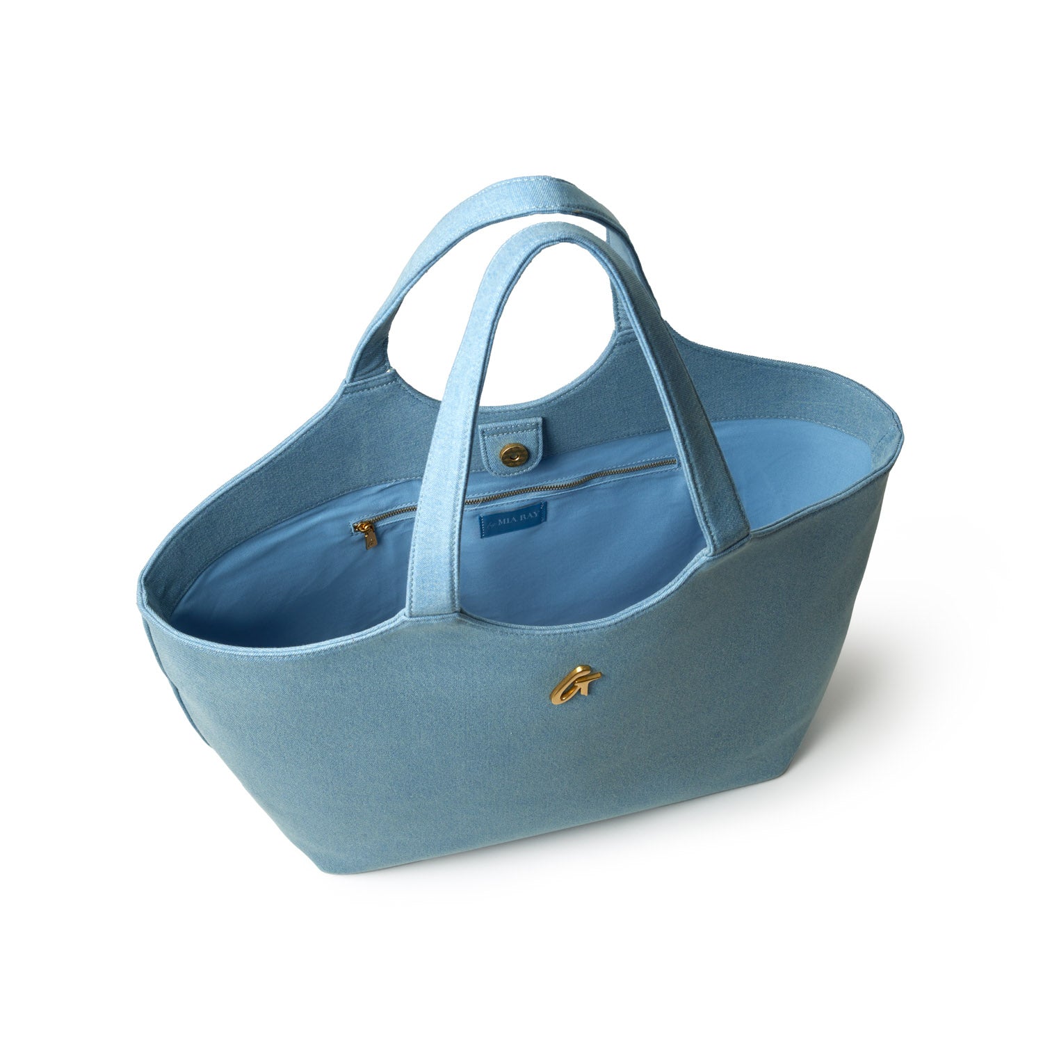 Light blue denim maxi tote bag with dual handles, gold hardware accent, and interior zip pocket, ideal for casual or shopping use.