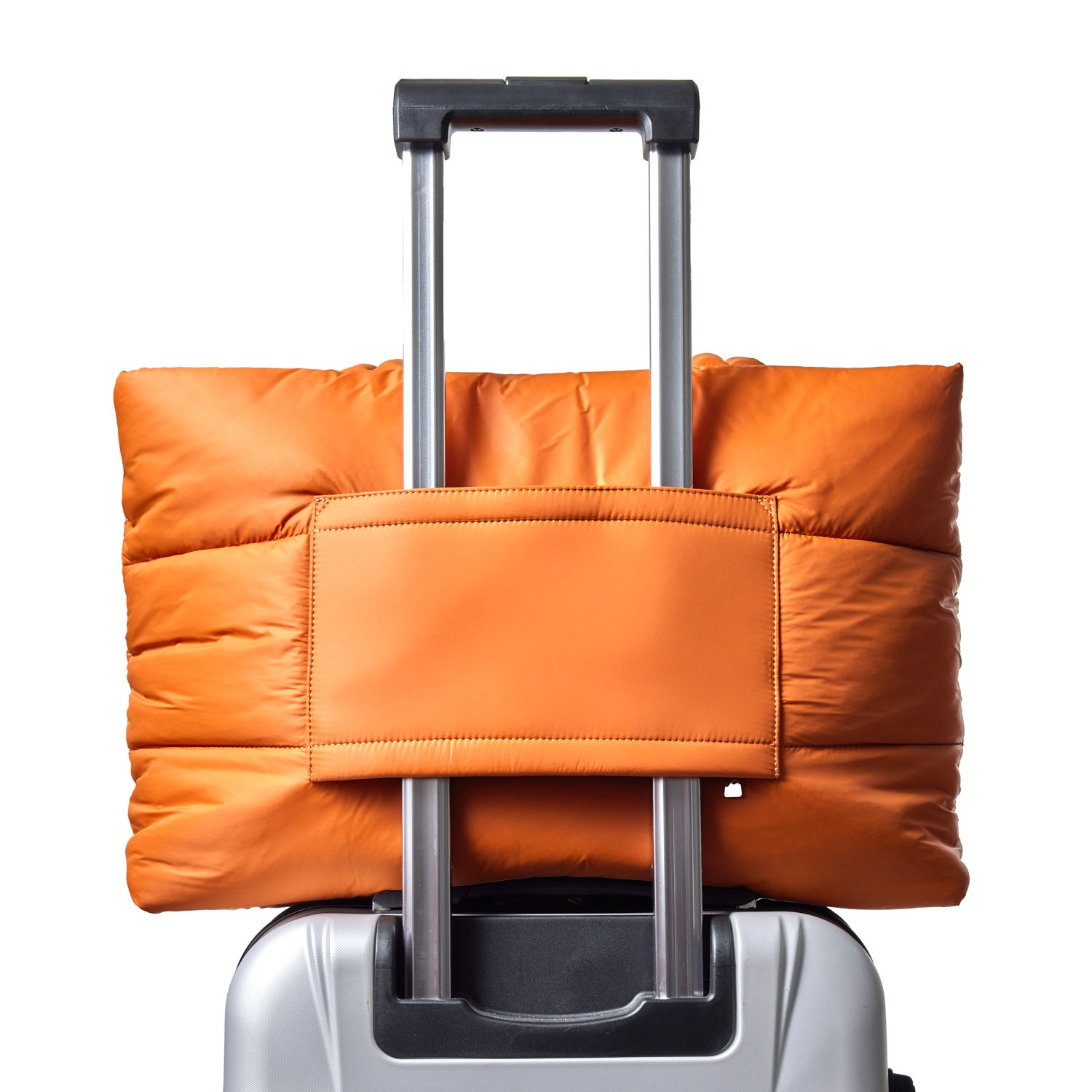 Brown athletic nylon tote secured on the handle of a silver suitcase, showcasing its practical design for travel.