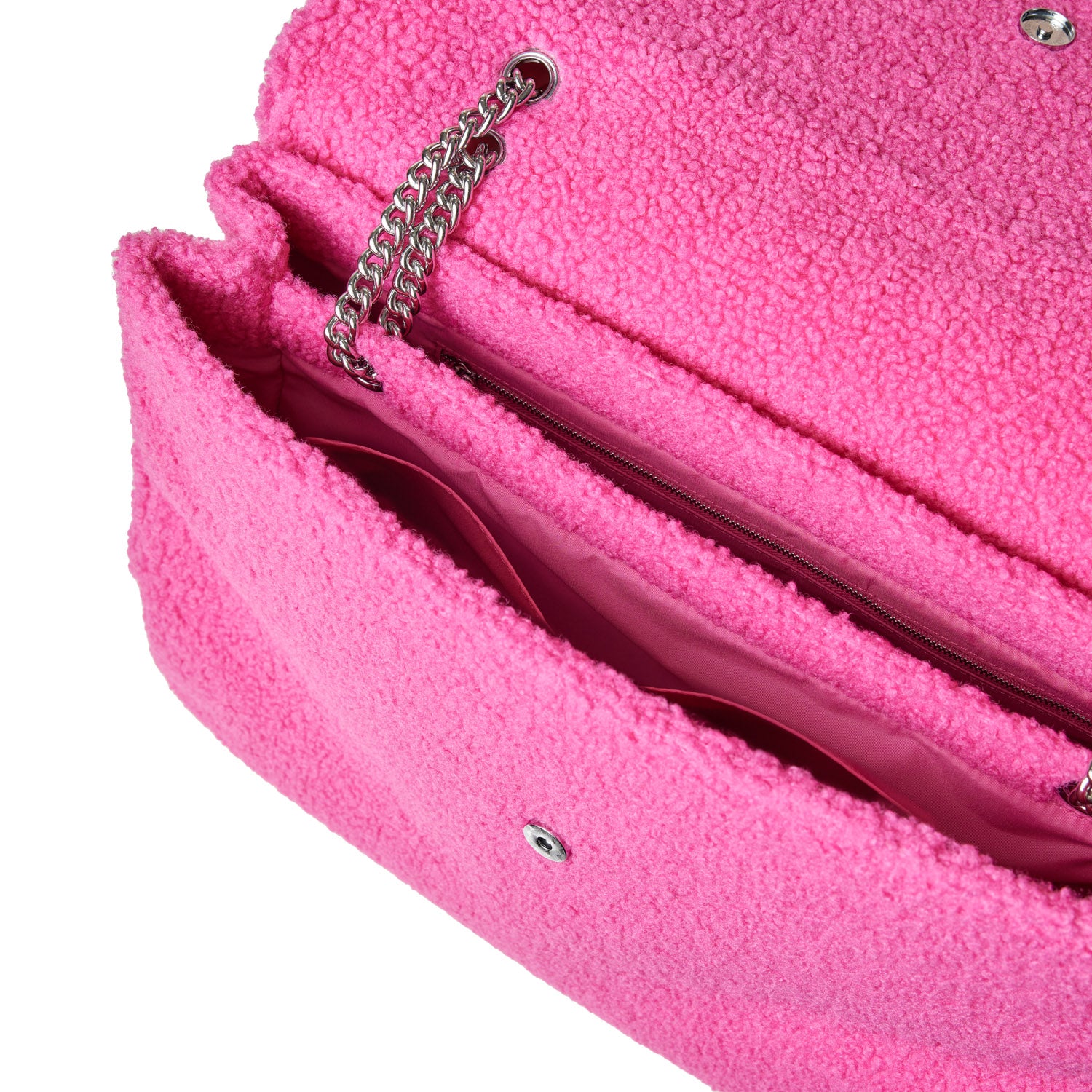 Open view of a bright pink, fluffy teddy flap bag with a silver chain strap and interior zip pocket.