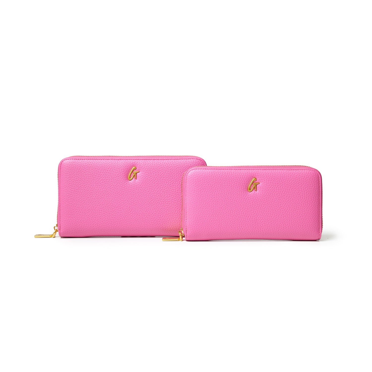 Two hot pink pebble wallets with gold zippers and a gold "G" logo, one larger and one smaller, on a white background.