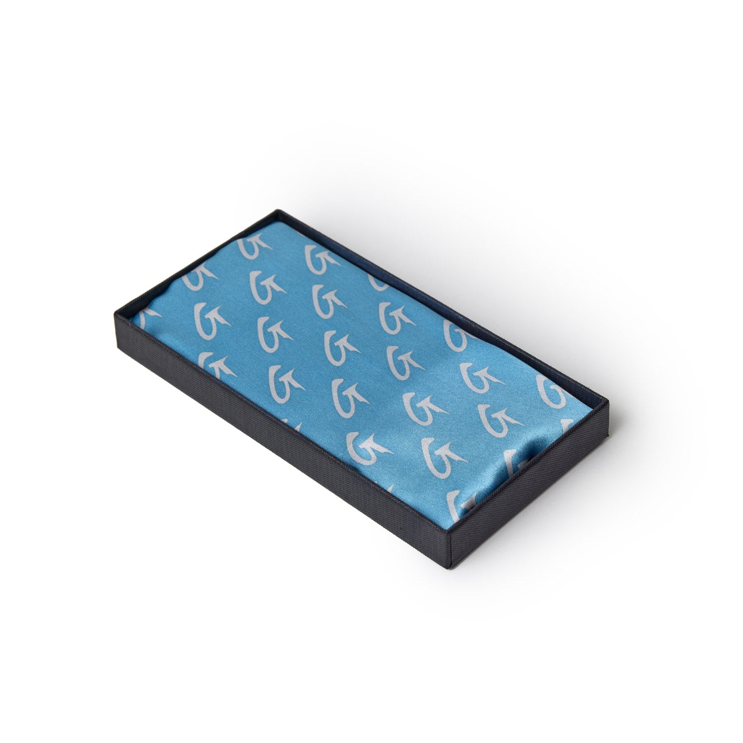 Large blue silk scarf with silver monogram pattern, displayed in a black presentation box.