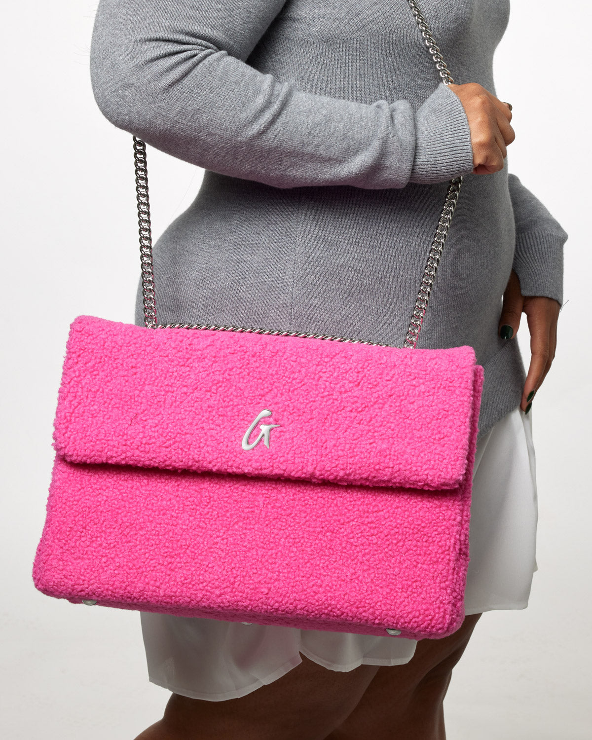 Large hot pink teddy flap bag with a silver chain strap and a white "G" logo on the front.