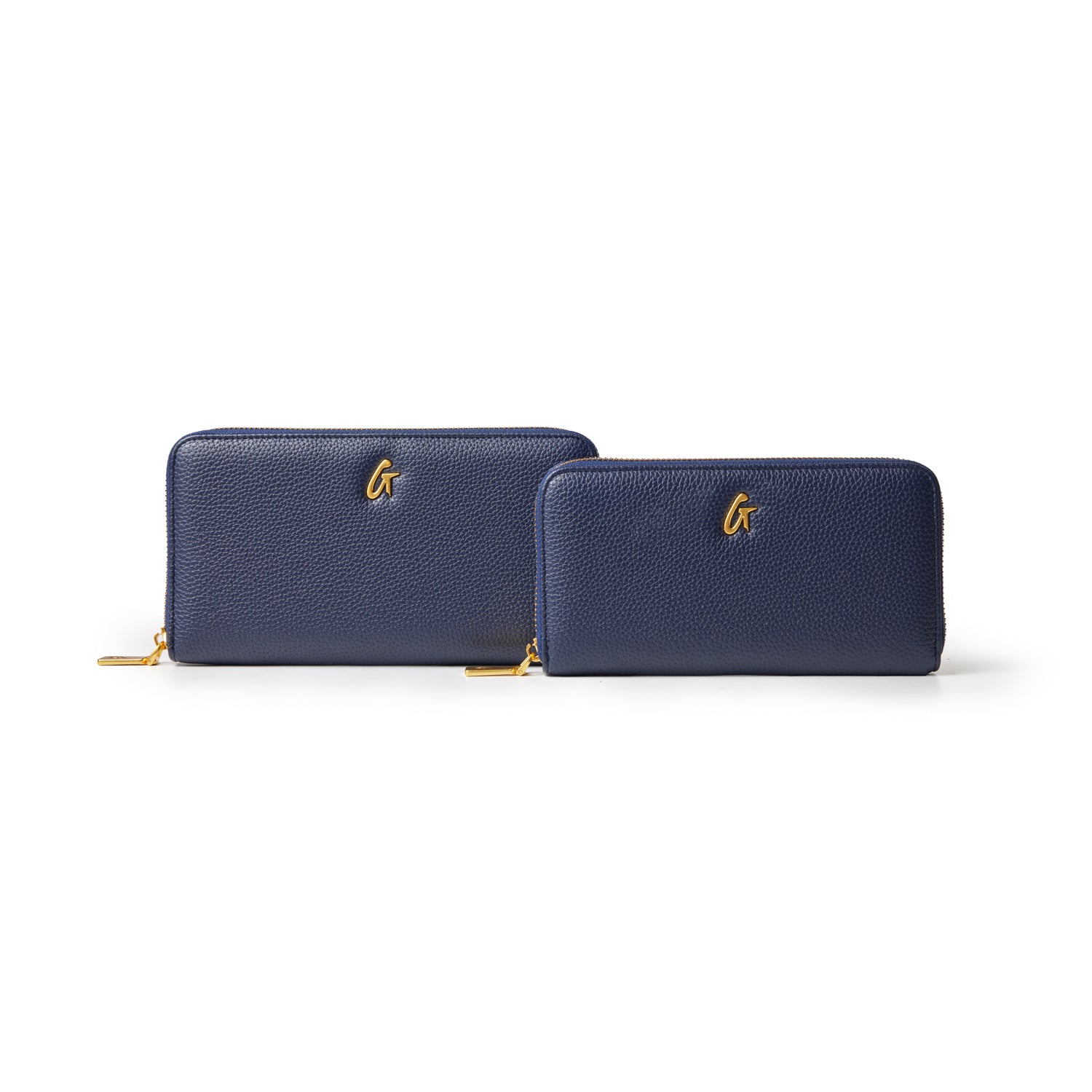 Navy pebble leather wallets with gold zipper pulls and a gold "G" logo, shown in two sizes on a white background.