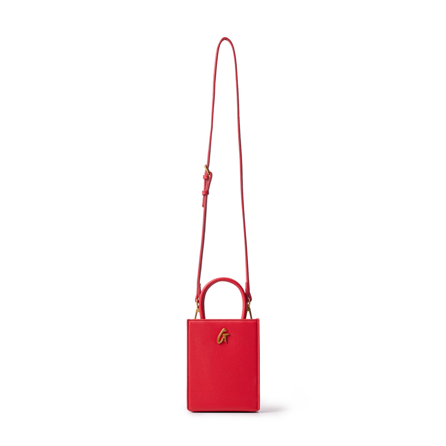 Red mini pebble leather tote bag with a top handle, gold logo detail, and adjustable shoulder strap on a white background.