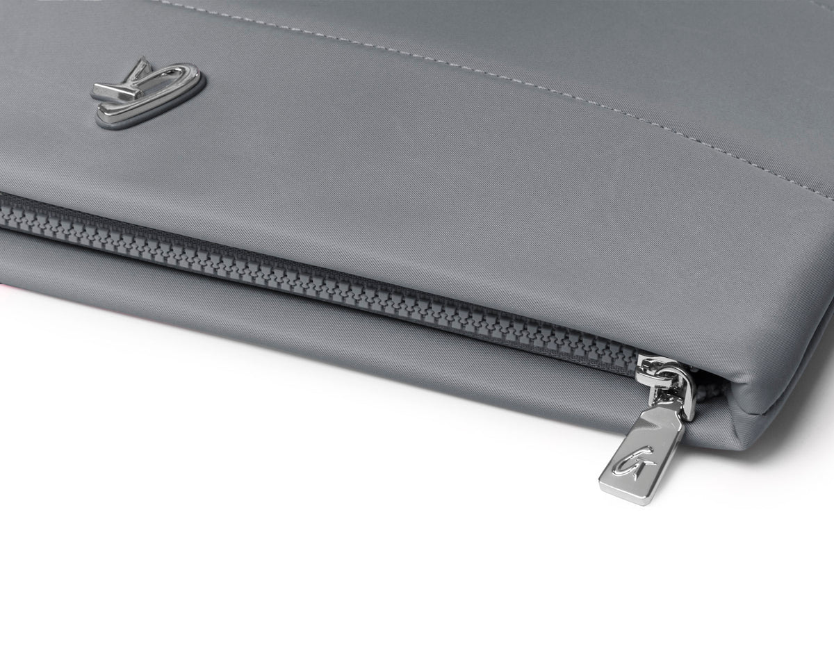 Gray nylon laptop sleeve featuring a sleek design and a zip closure for secure storage. Ideal for stylish protection.