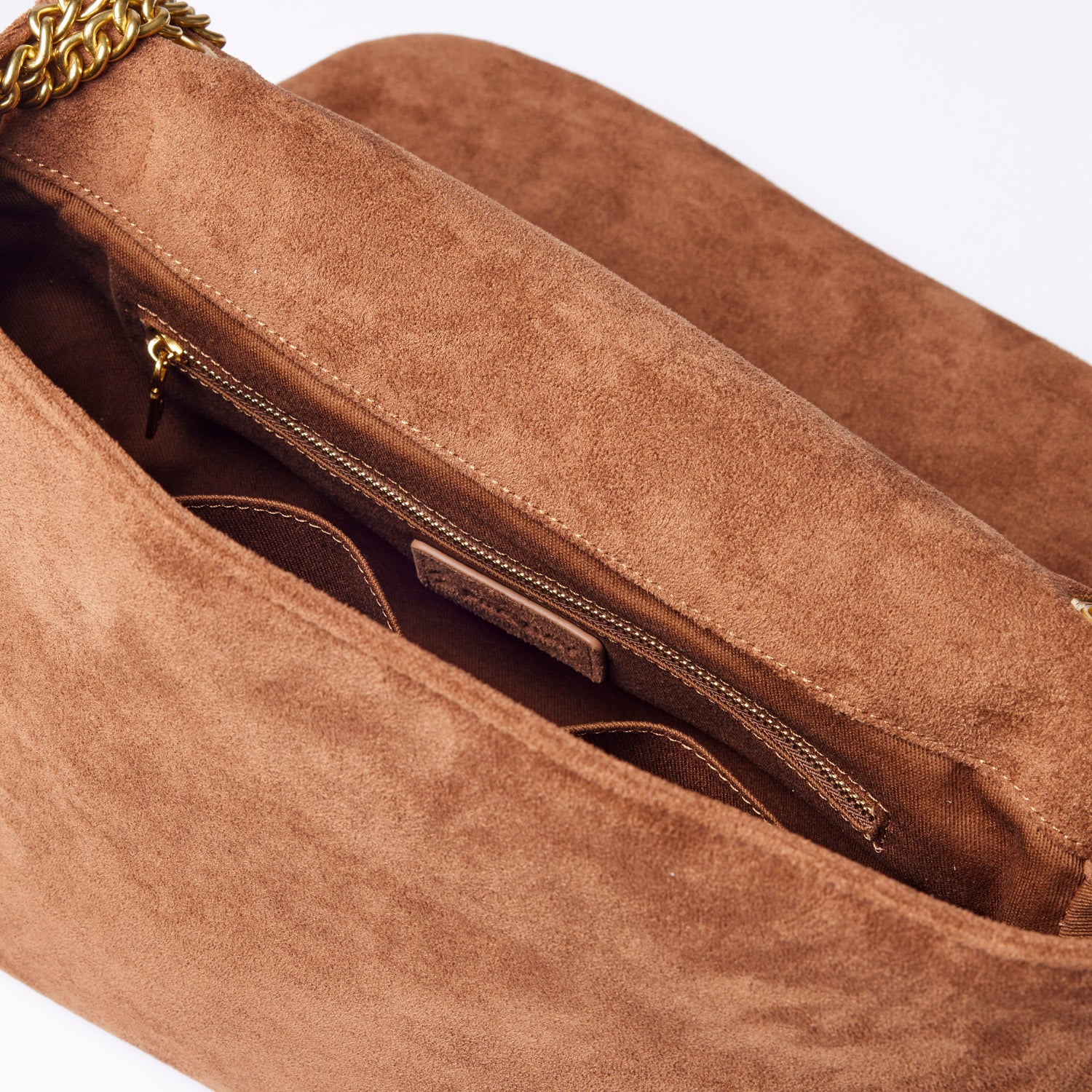 Medium brown suede flap bag with a soft texture and gold chain strap, featuring an interior zip pocket for organization.