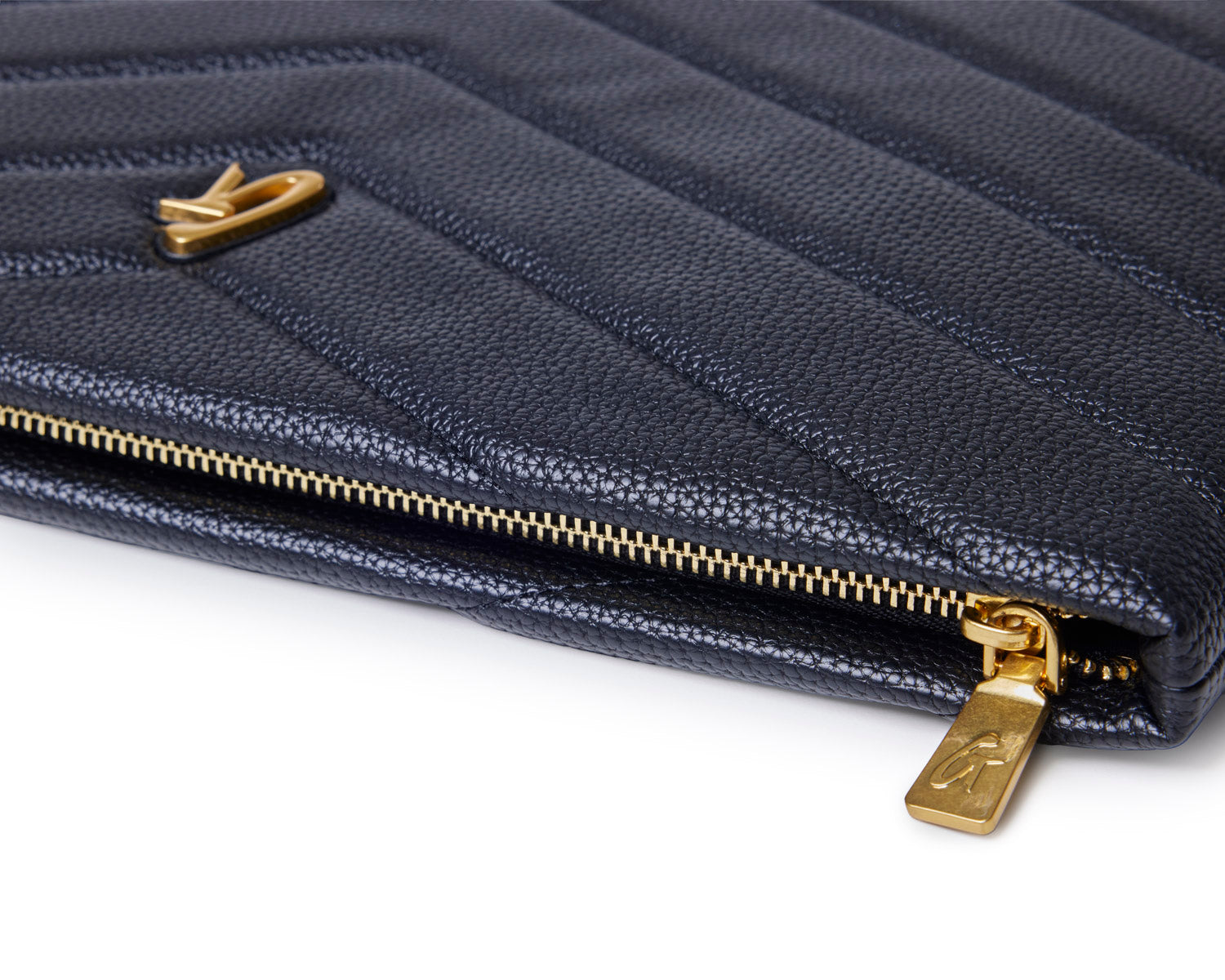 Black pebble laptop sleeve featuring a quilted design and gold zipper detail, perfect for stylish protection.