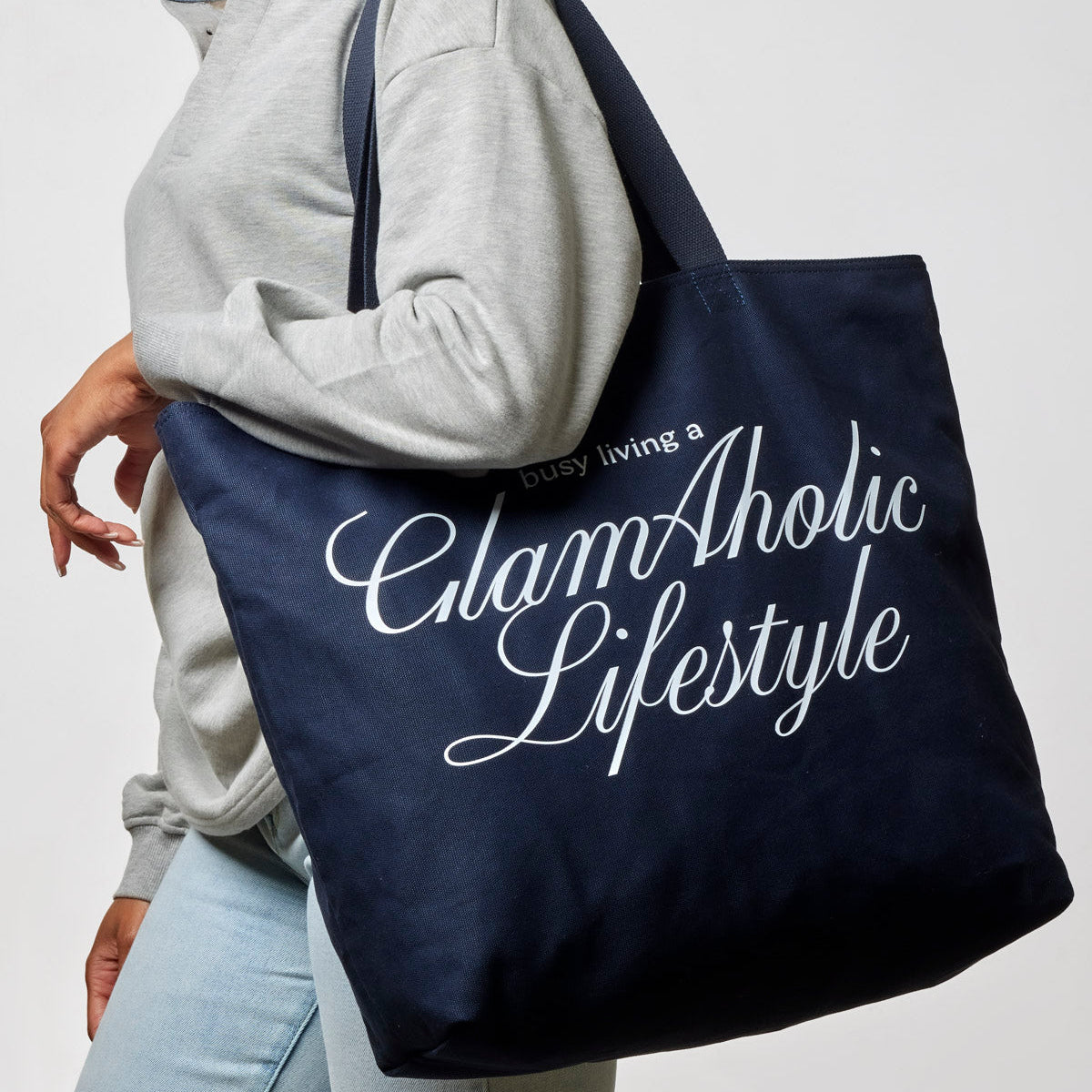Navy canvas tote bag featuring "busy living a GlamAholic Lifestyle" text, perfect for stylish everyday use.