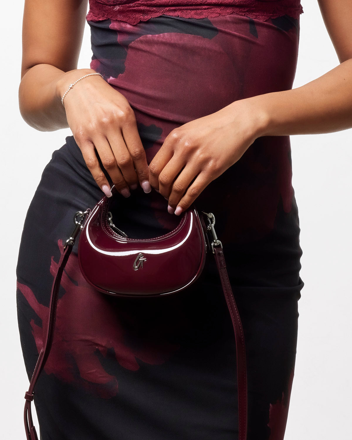 Stylish Nano Mirror Hobo Bag in mirror burgundy, worn crossbody with a sleek design, perfect for chic outings.