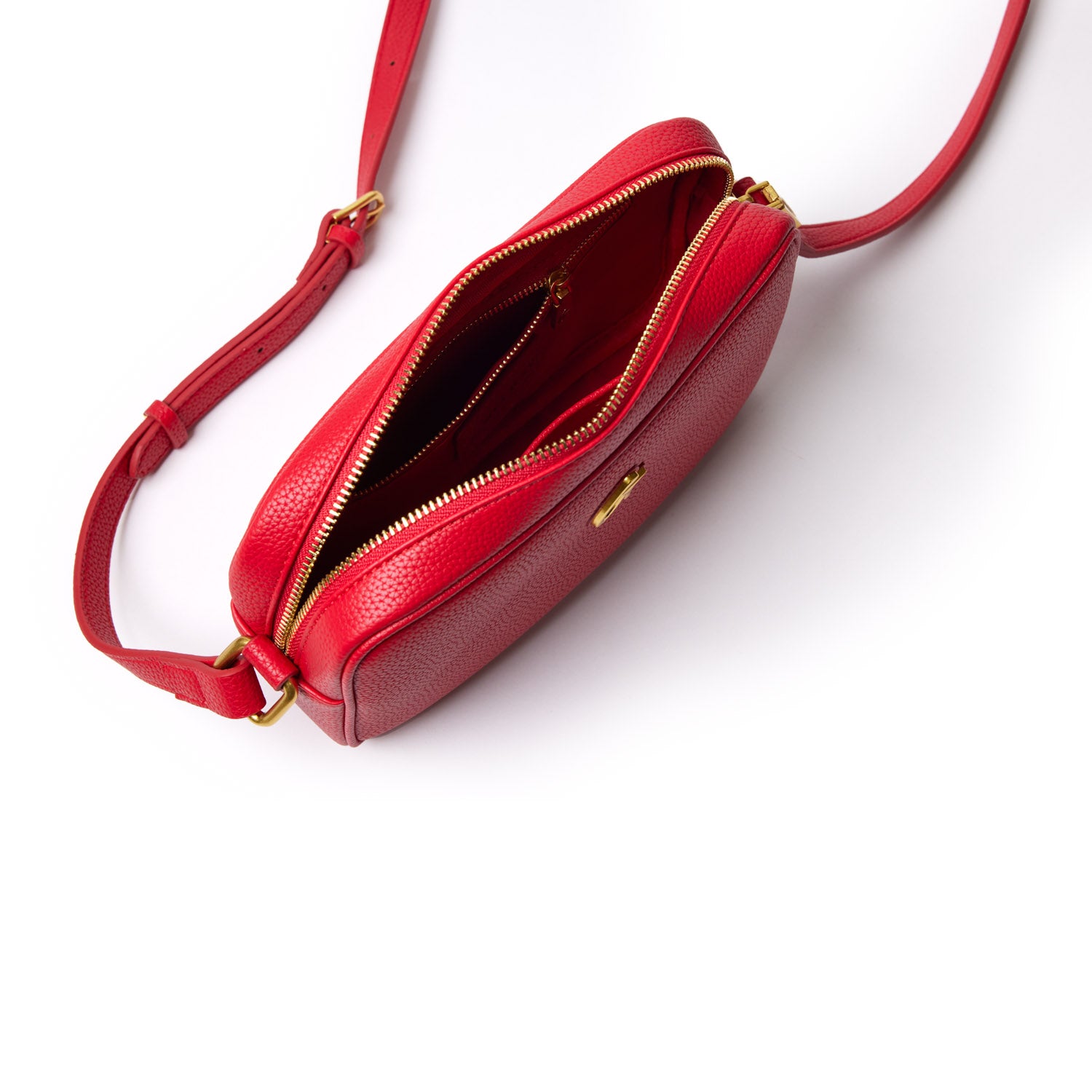 Red mini pebble camera bag with gold zipper, adjustable strap, and interior compartments on a white background.