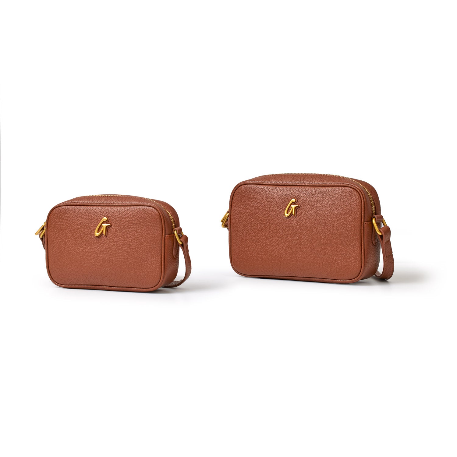 Two brown pebble-textured camera bags with gold "G" logo, adjustable strap, and zip closure, shown in small and large sizes.