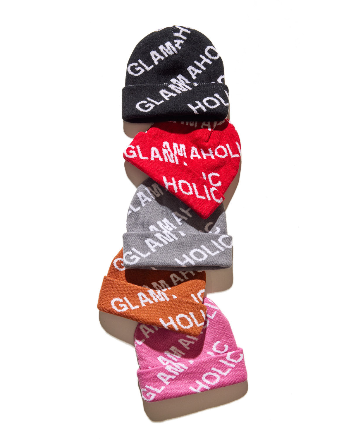 Set of five colorful monogram beanies in black, red, gray, orange, and pink with "Glam Aholic" text, stacked vertically.