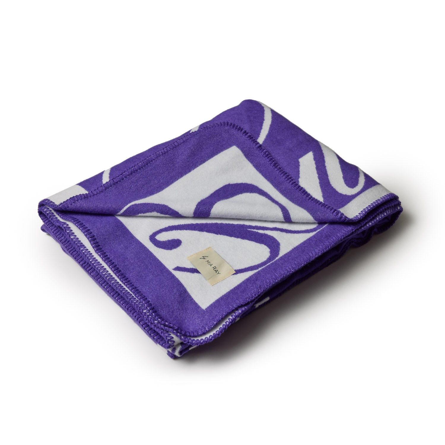 Purple luxury throw blanket with bold white and purple abstract patterns, folded neatly on a white background.