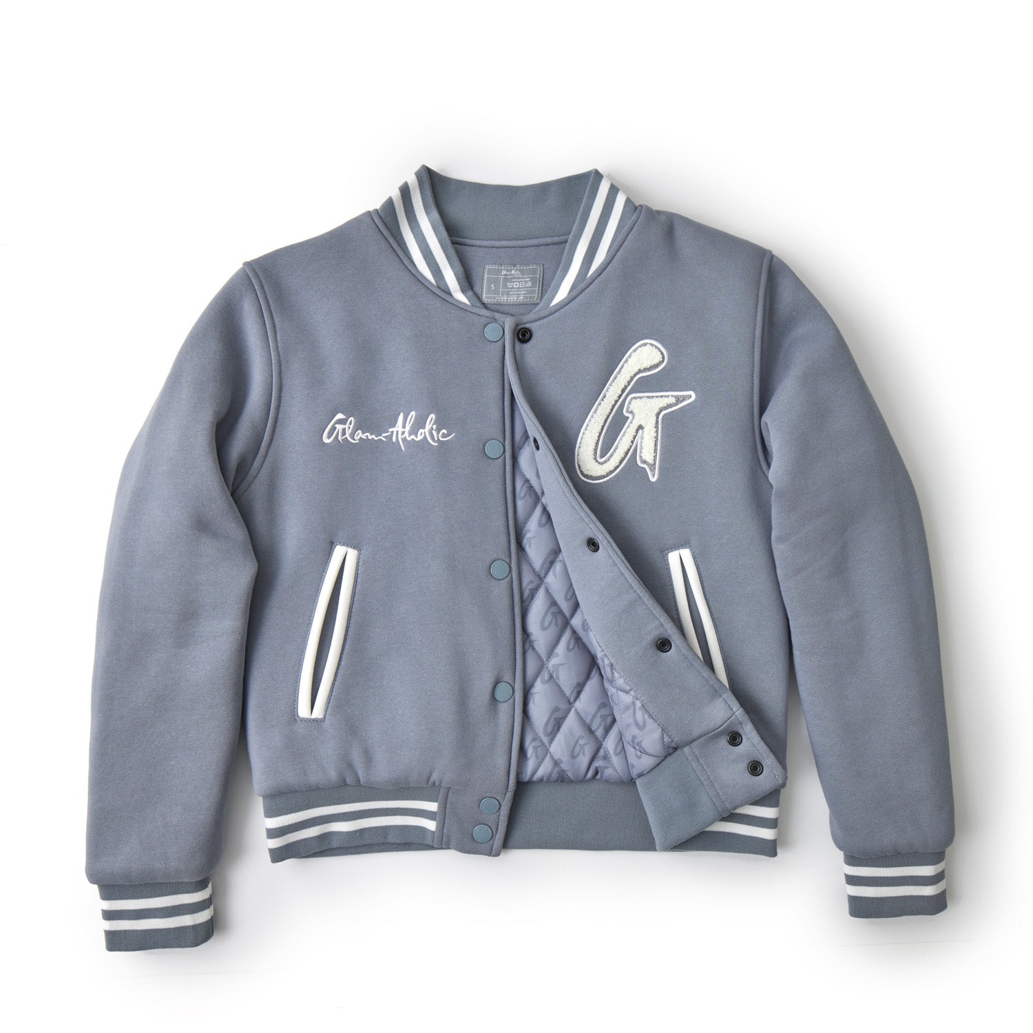 Gray varsity jacket with striped cuffs, collar, and waistband, featuring embroidered patches and a quilted inner lining.