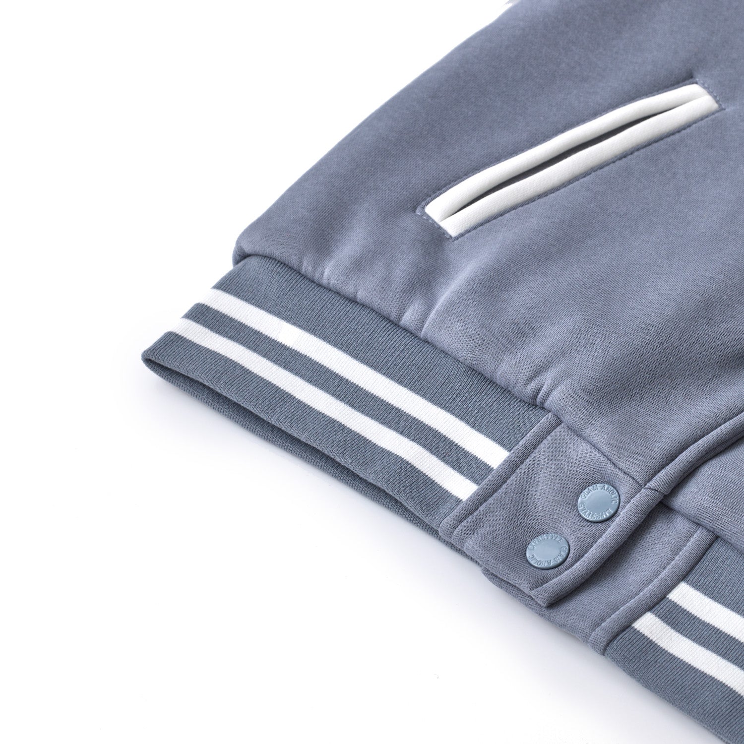 Gray varsity jacket with striped cuffs, snap buttons, and a front pocket, featuring a classic athletic style.