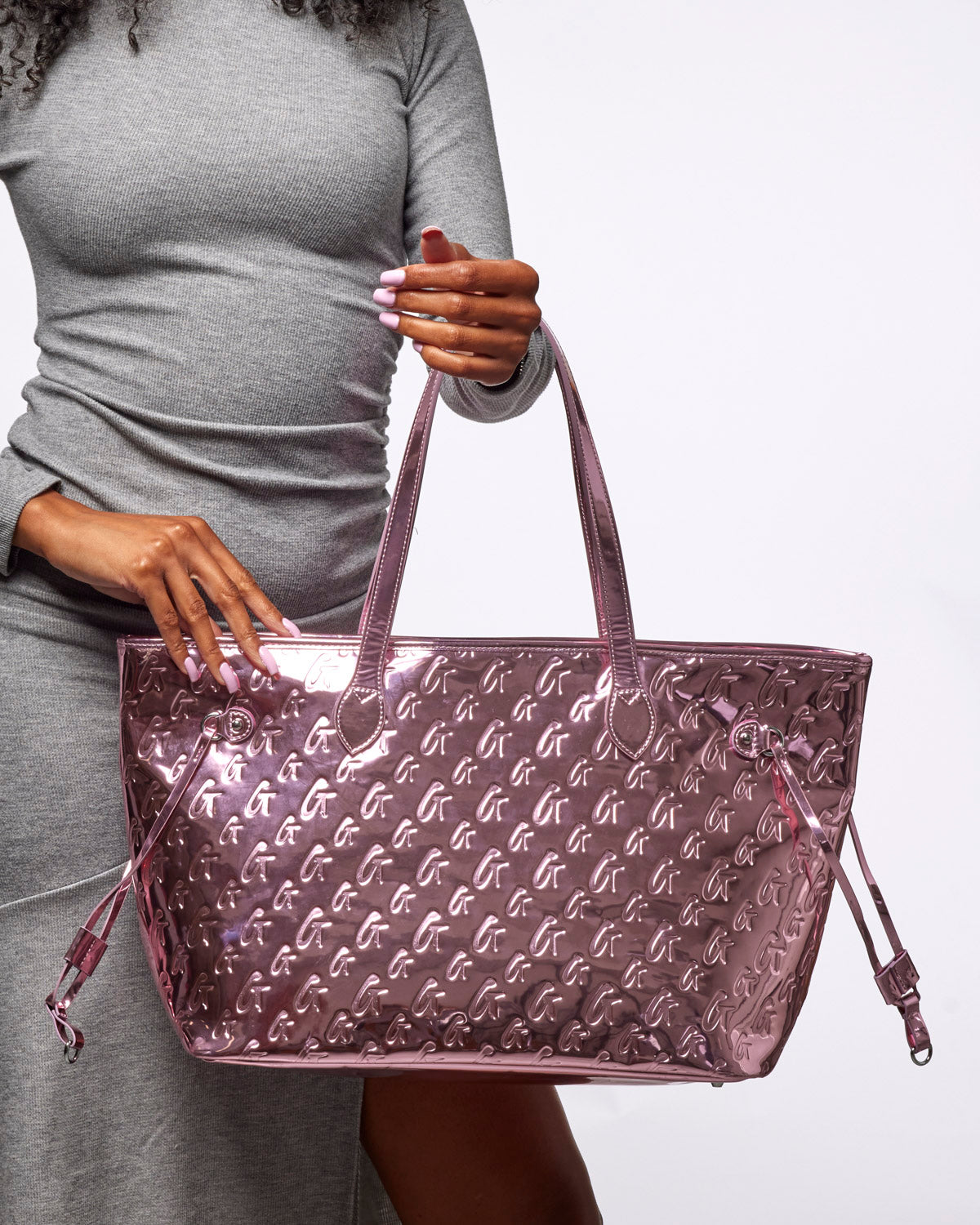 Metallic pink tote bag featuring a monogram design, perfect for stylish and affordable luxury. Ideal for everyday use.