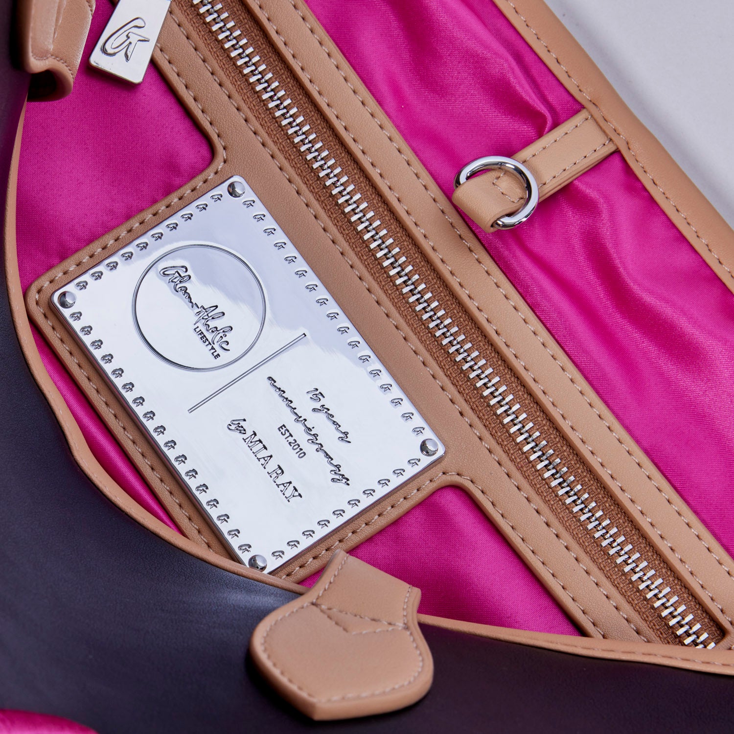 Interior view of the Original Glam Tote in black and pink, showcasing the logo plate and vibrant lining.