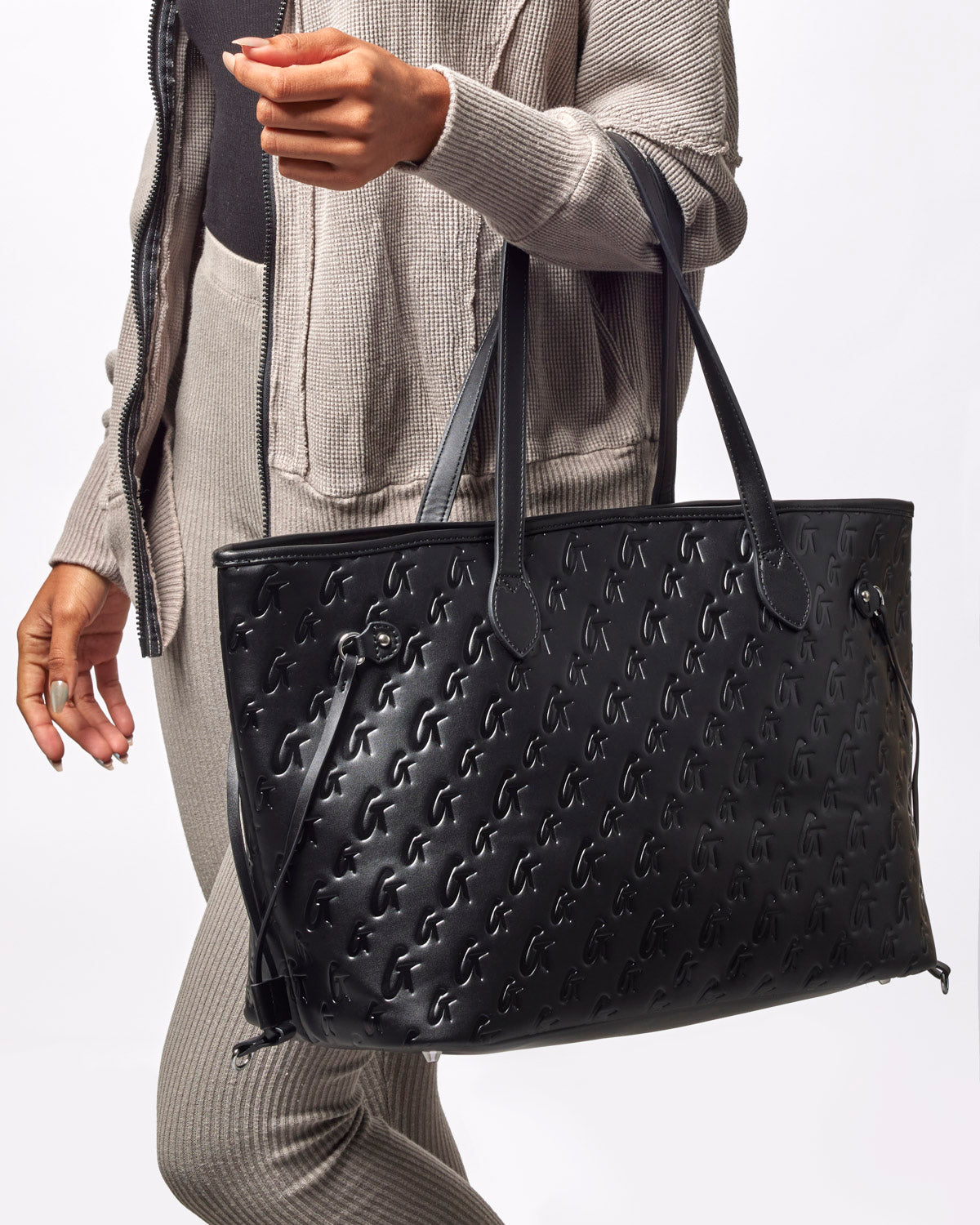 Stylish black monogram tote bag with embossed logo, perfect for everyday use and adding luxury to any outfit.