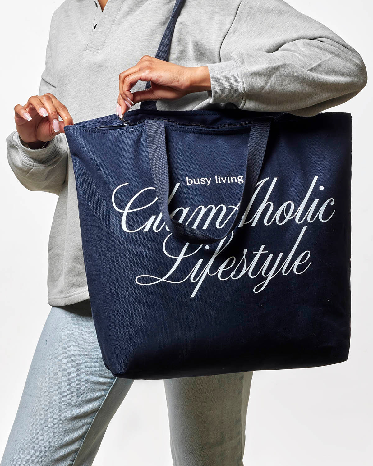 Navy canvas tote bag with "busy living" and "Glam-Aholic Lifestyle" printed in white, perfect for stylish everyday use.