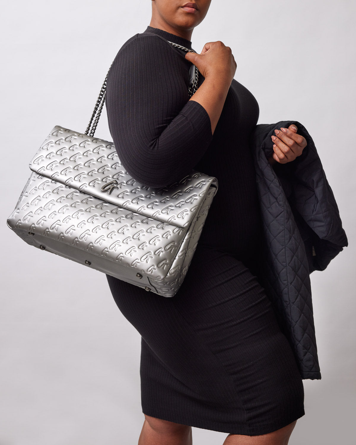 XL Monogram Flap Bag in platinum, showcased by a model in a fitted black dress, exuding luxury and style.