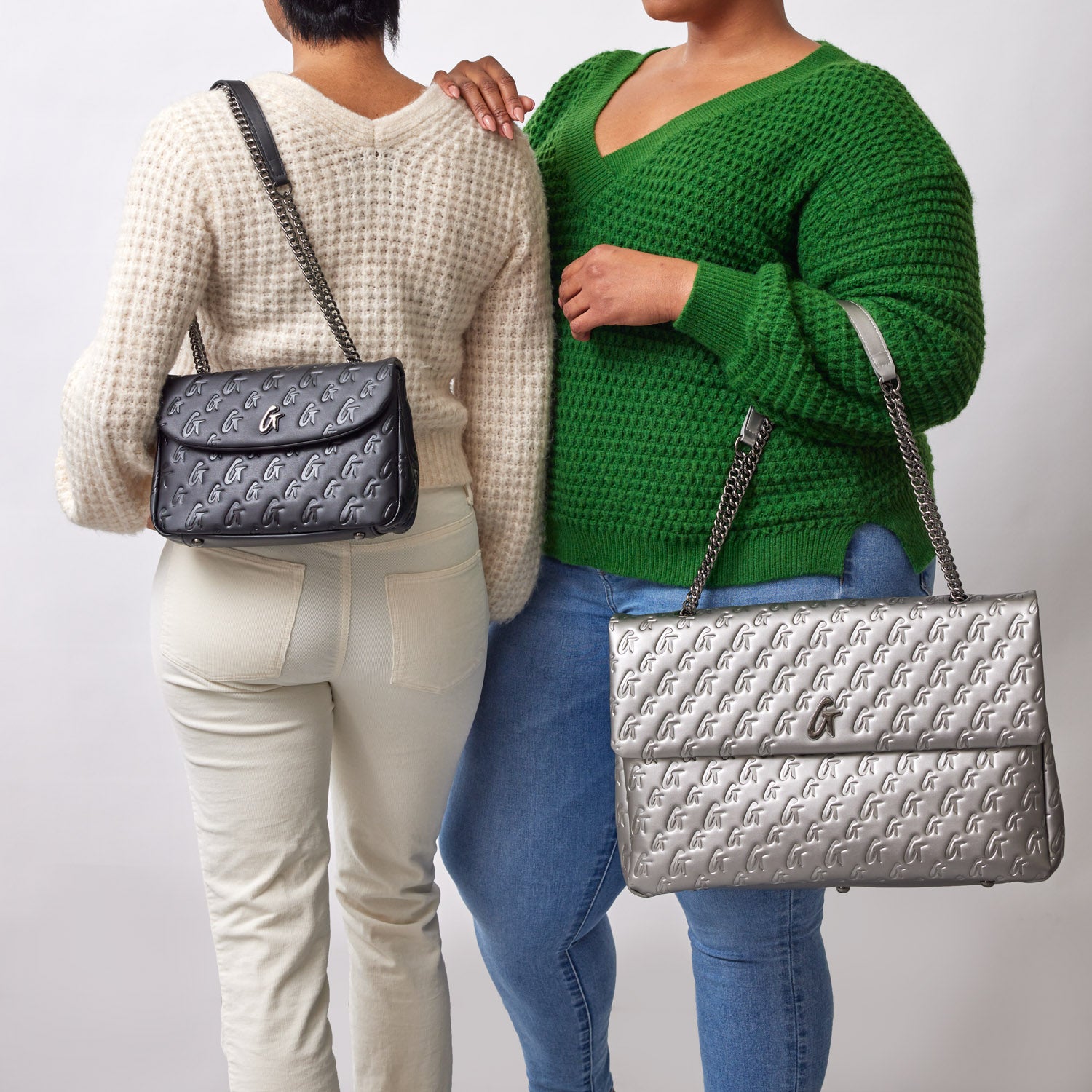 Two women showcase the XL Monogram Flap Bag in Platinum, highlighting its stylish design and versatility.