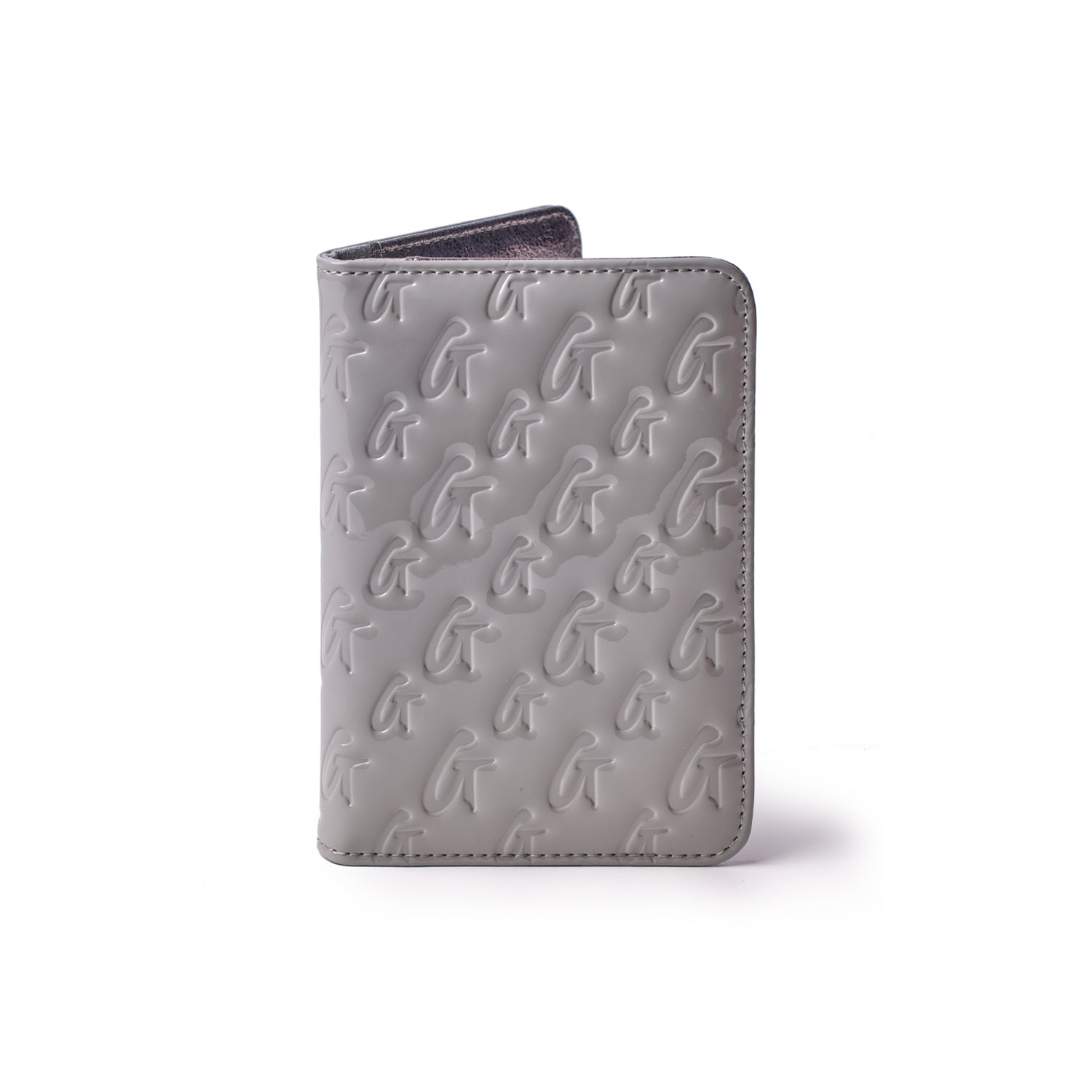 Mirror gray monogram passport holder with embossed G and G logo pattern, standing upright against a white background.