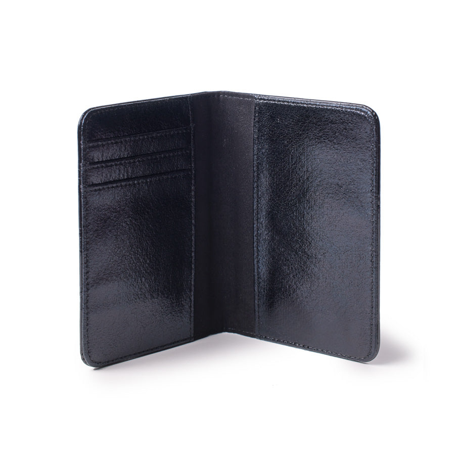 Mirror black monogram passport holder opened, showing interior card slots and sleek, reflective black leather design.