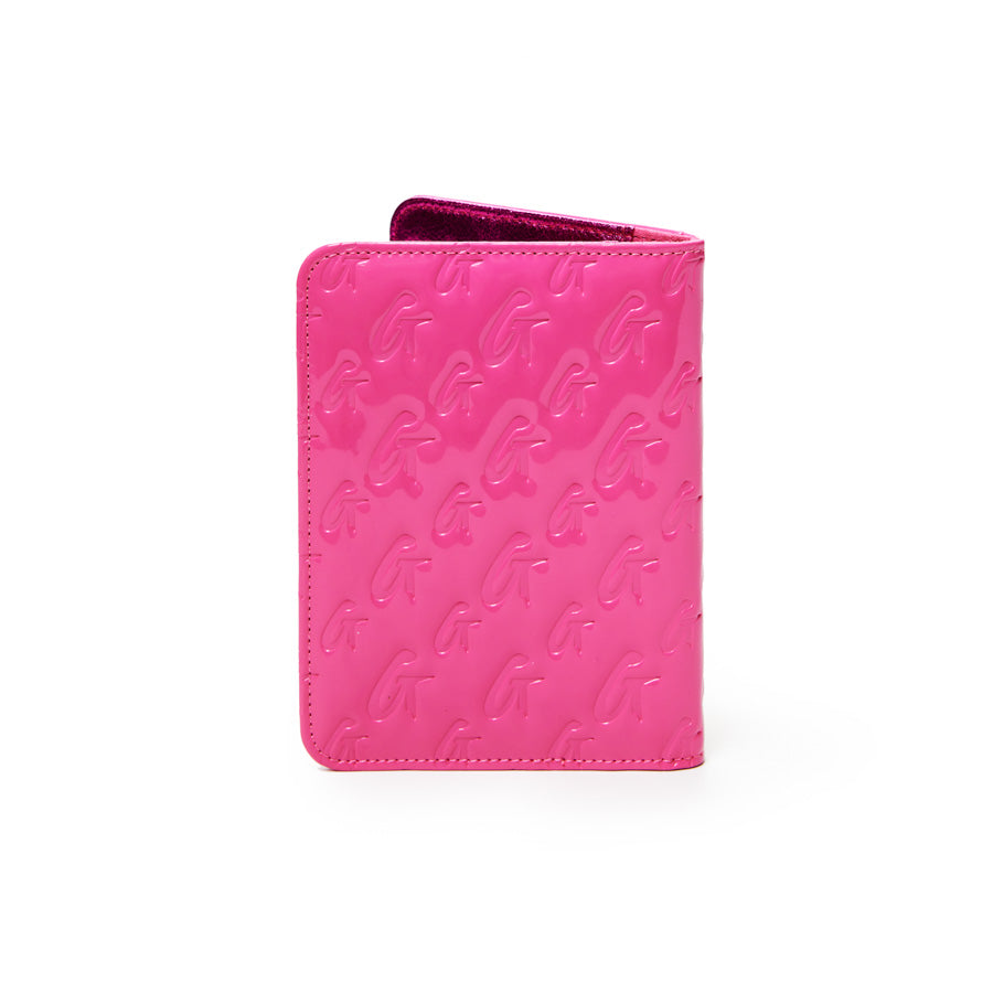 Mirror hot pink monogram passport holder with embossed G patterns and a velvet interior.