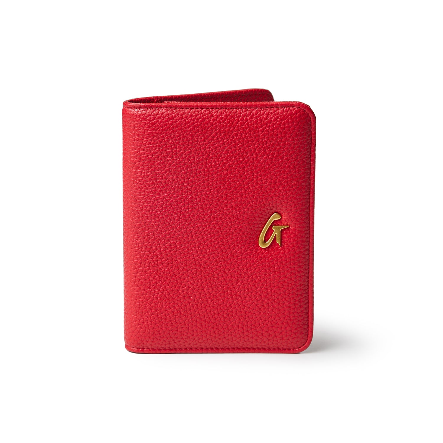 Red Pebble leather passport holder with a gold "G" logo on the front. Compact, textured travel accessory for passports.