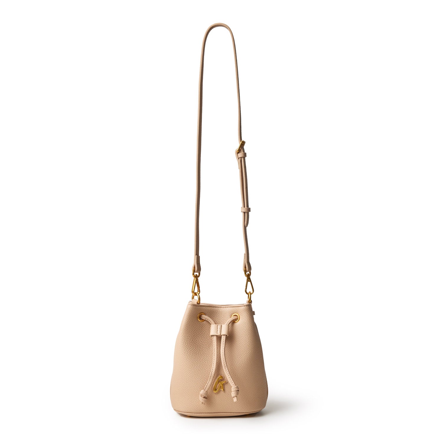 Mini Pebble Bucket Bag in nude color with a drawstring closure, gold accents, and a long adjustable strap.