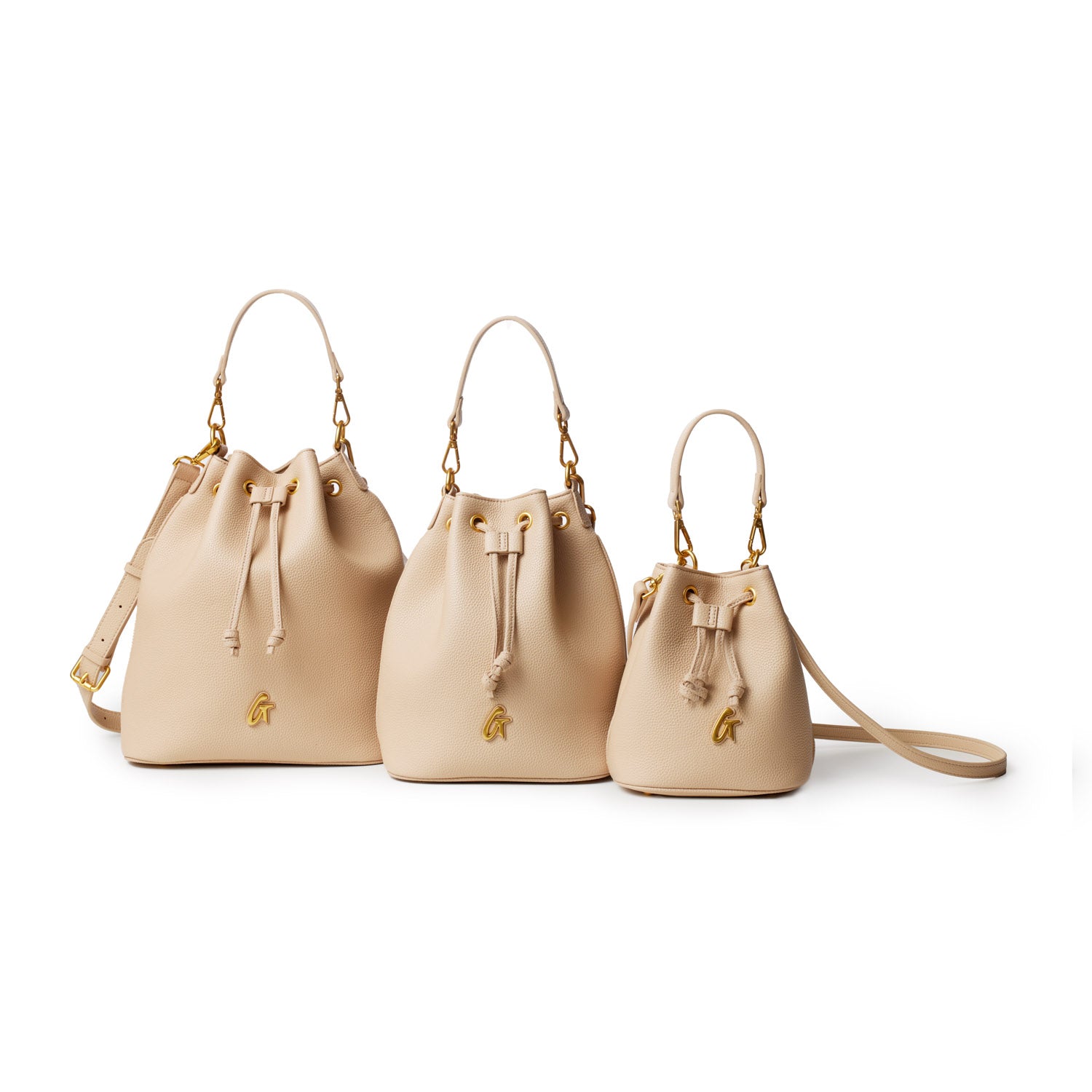 Three beige mini pebble bucket bags with gold hardware, drawstring closure, and top handles, arranged in size order.