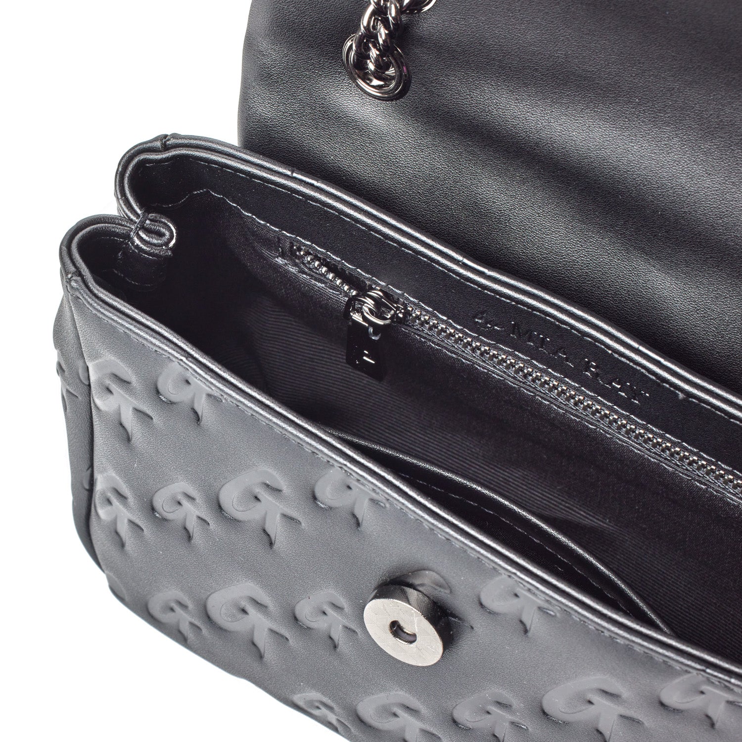 Black mini Monogram Flap Bag with embossed G logo pattern, chain strap, and interior zip pocket.