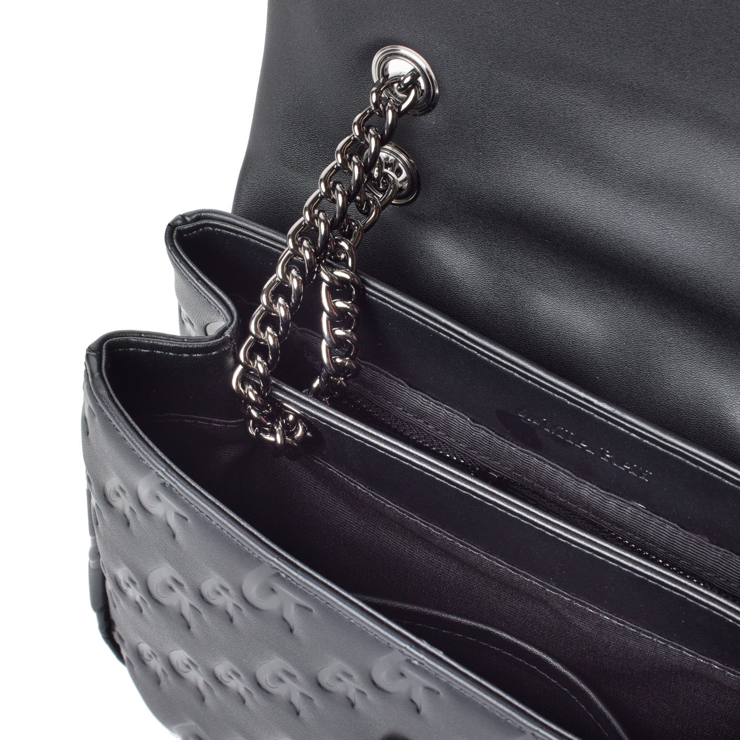 Close-up of a black medium monogram flap bag with a chain strap, showing interior compartments and embossed logo.