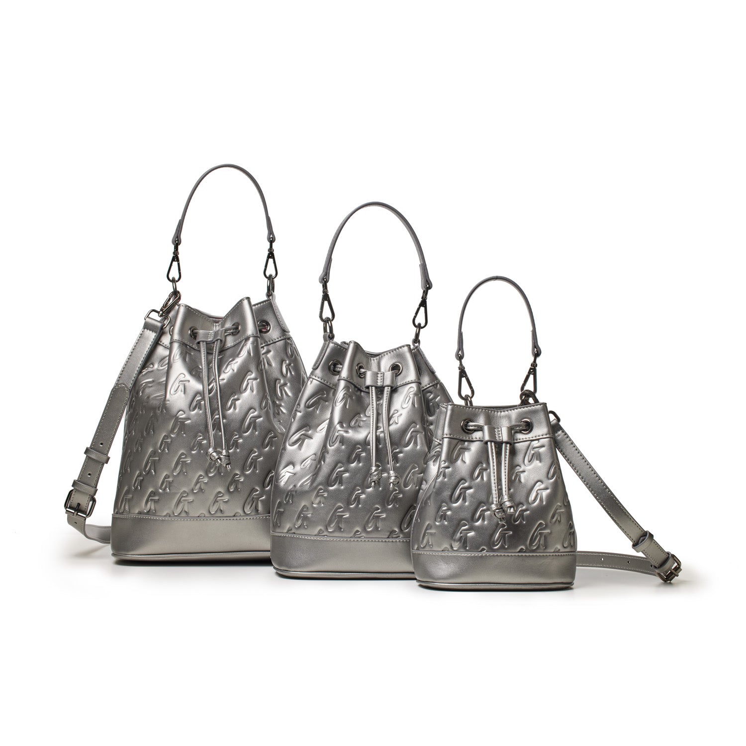 Three silver mini monogram bucket bags with adjustable straps, embossed logo pattern, and drawstring closures.