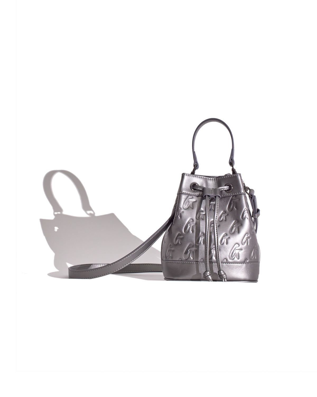Mini Monogram Bucket Bag in platinum metallic leather with embossed G logo pattern, drawstring closure, and top handle.