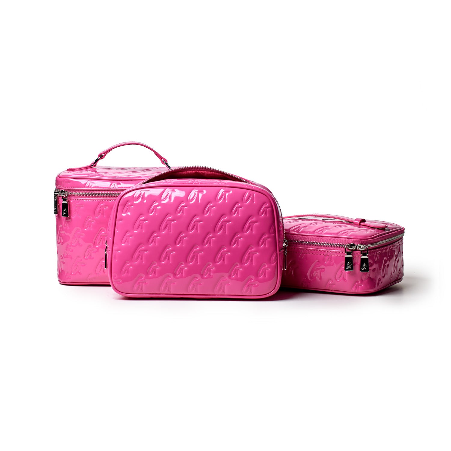 Small hot pink monogram toiletry bag set with embossed G pattern, featuring zippers and a handle, on a white background.