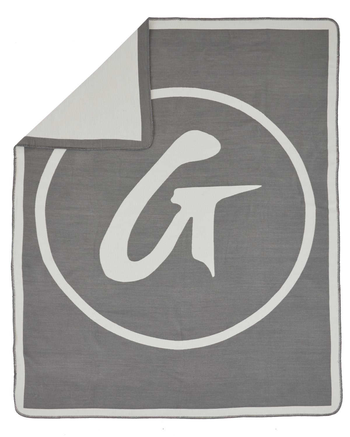 Gray throw blanket with a large white logo design, partially folded to show the soft, cozy fabric.