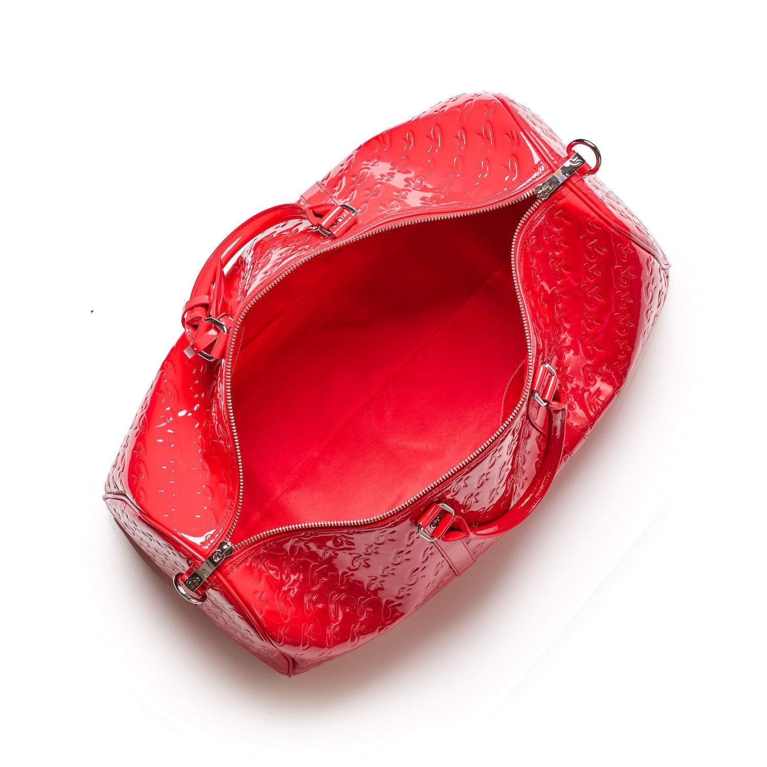 Open red Monogram Duffle Bag with embossed pattern, shiny finish, and interior space for travel or gym use.