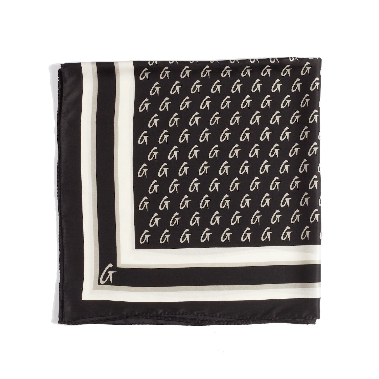 Large black silk scarf with monogram pattern and border design, featuring white and beige accents.