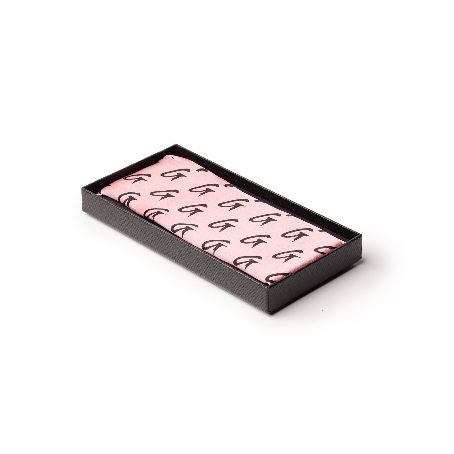 Pink silk scarf with a black monogram pattern, neatly folded inside a black presentation box.