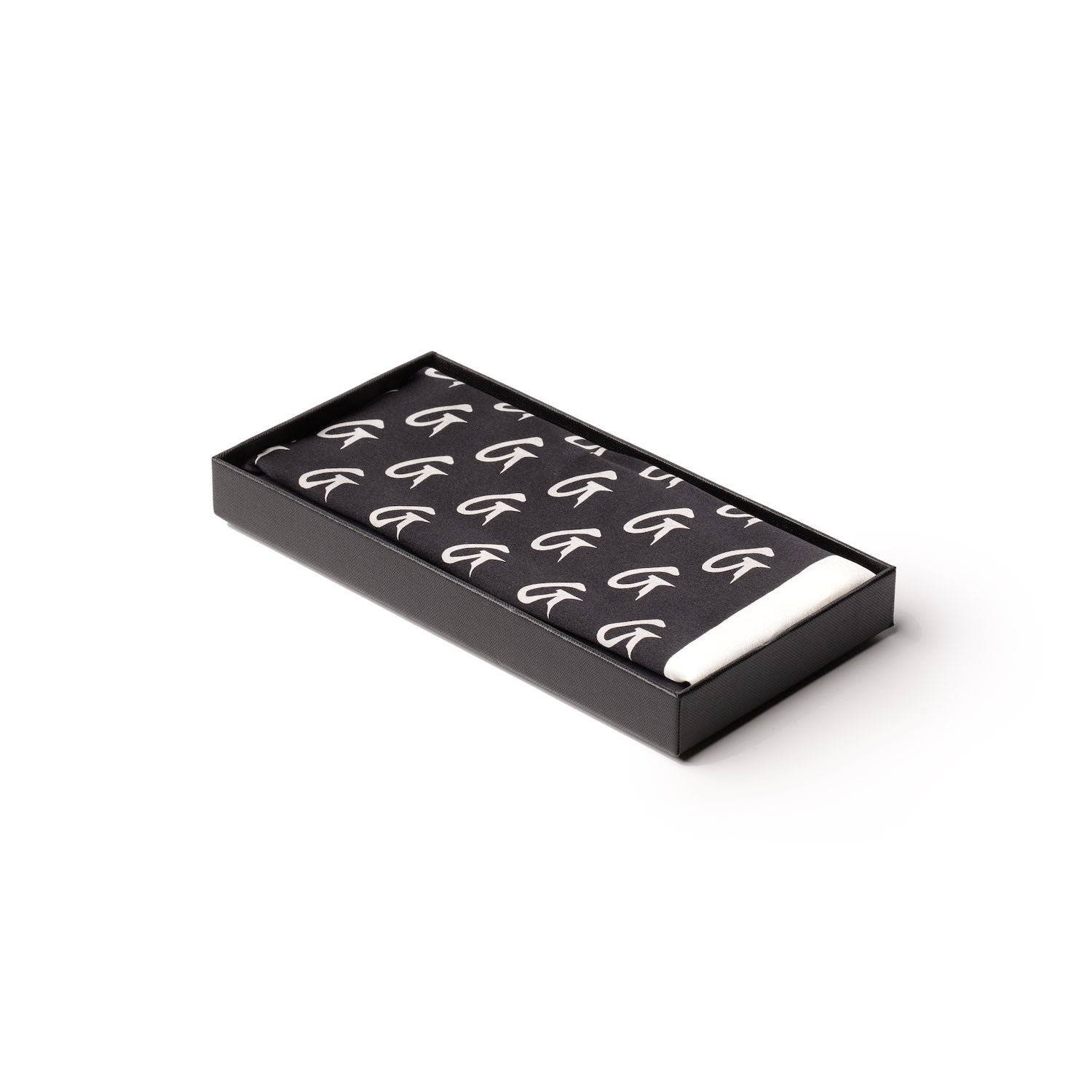 Black silk scarf with large white monogram pattern, neatly folded inside a black presentation box.