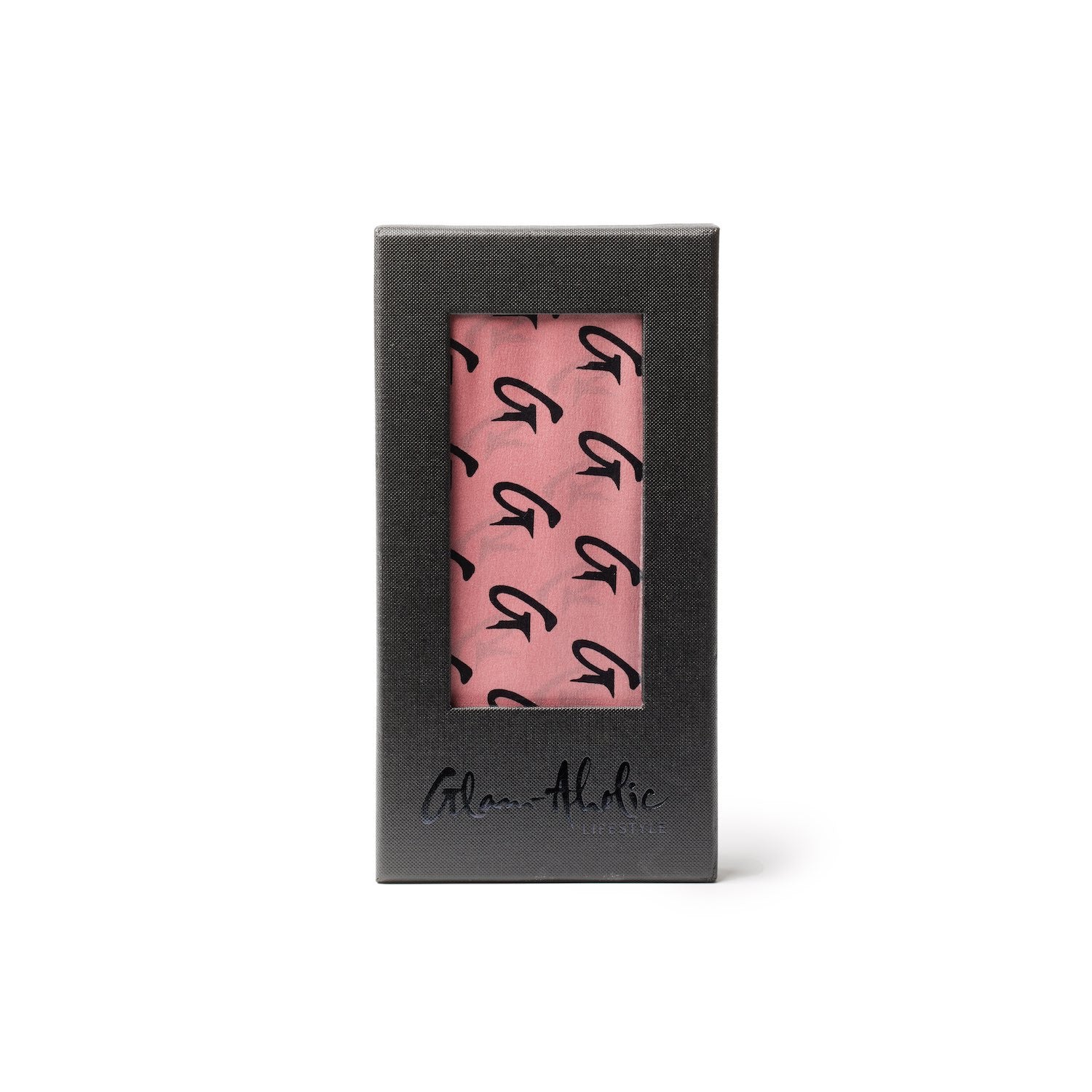 Large pink silk scarf with black monogram pattern, packaged in a black box with a clear window.